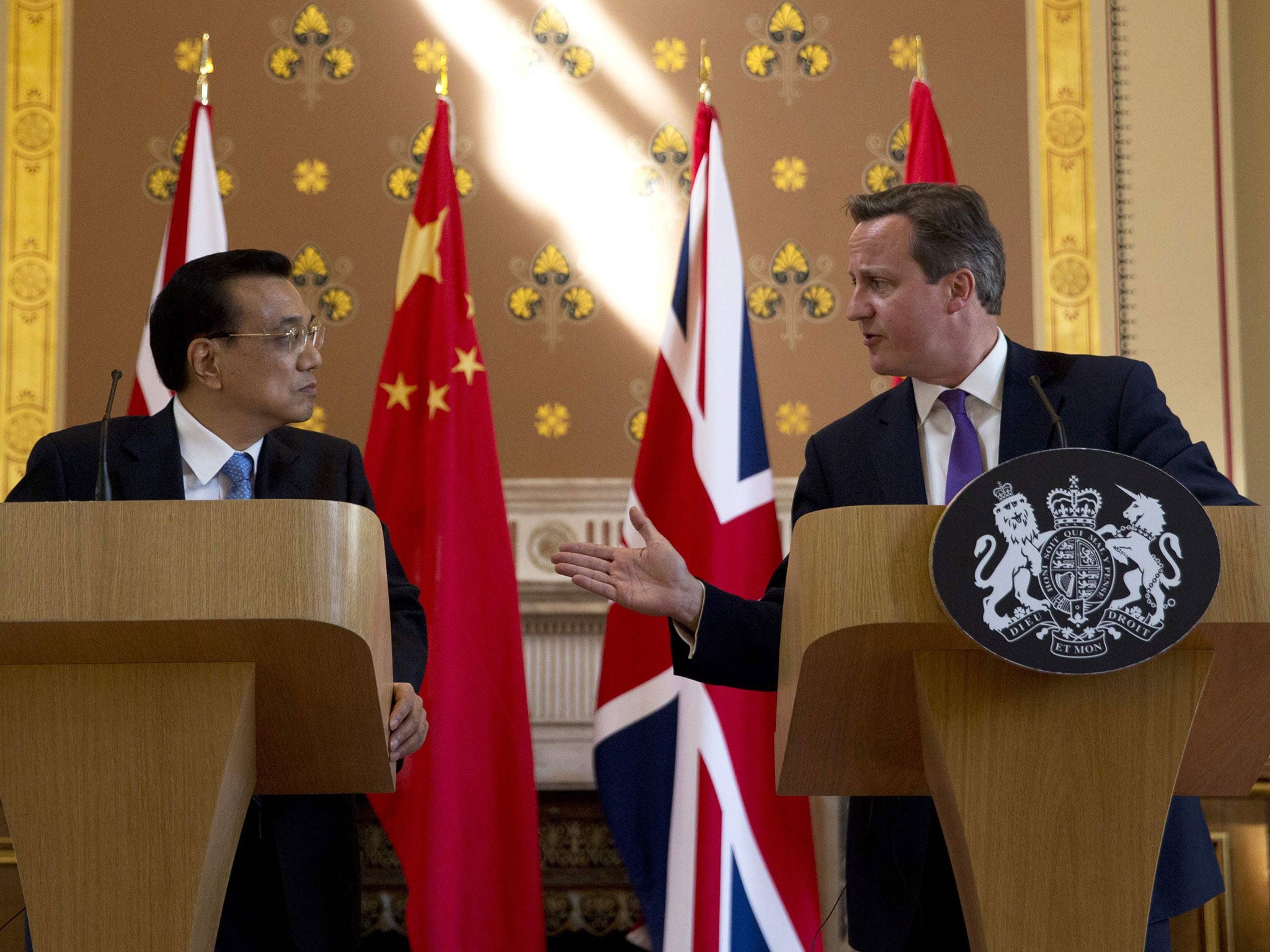 Chinese Premier Li Keqiang (L) looks on as Britain's Prime Minister David Cameron (R) speaks during a joint press conference in London on June 17, 2014.