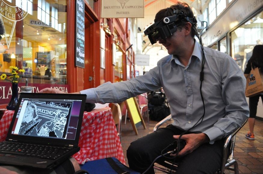 Iain Cairns tries out the glasses while a laptop shows what he is seeing.