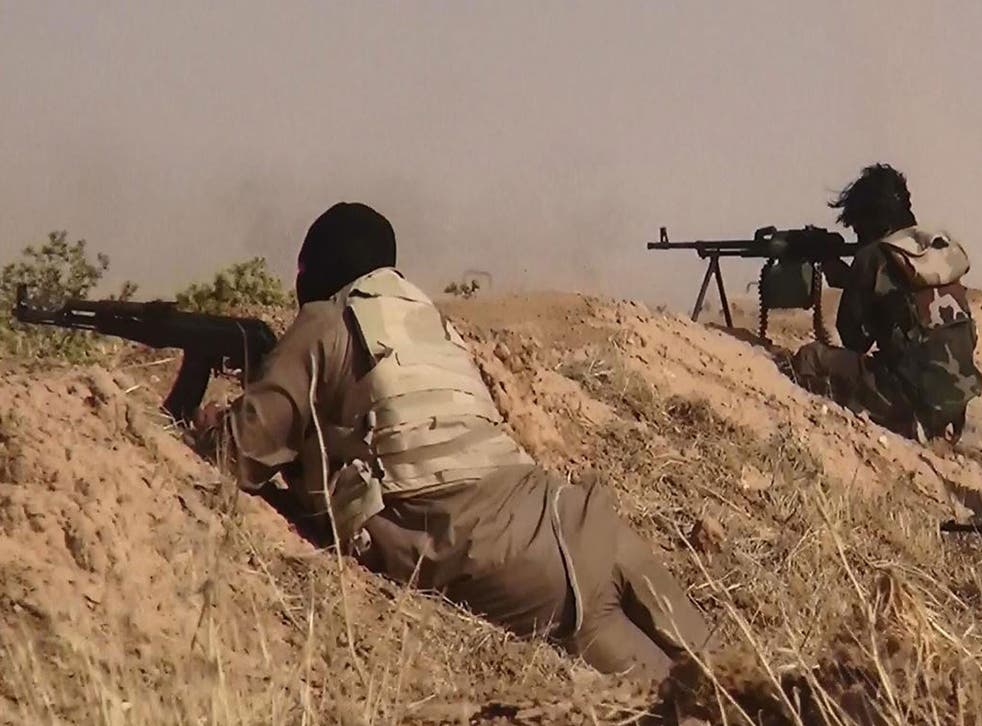 Fighters from the Isis aiming at advancing Iraqi troops at an undisclosed location near the border between Syria and Iraq