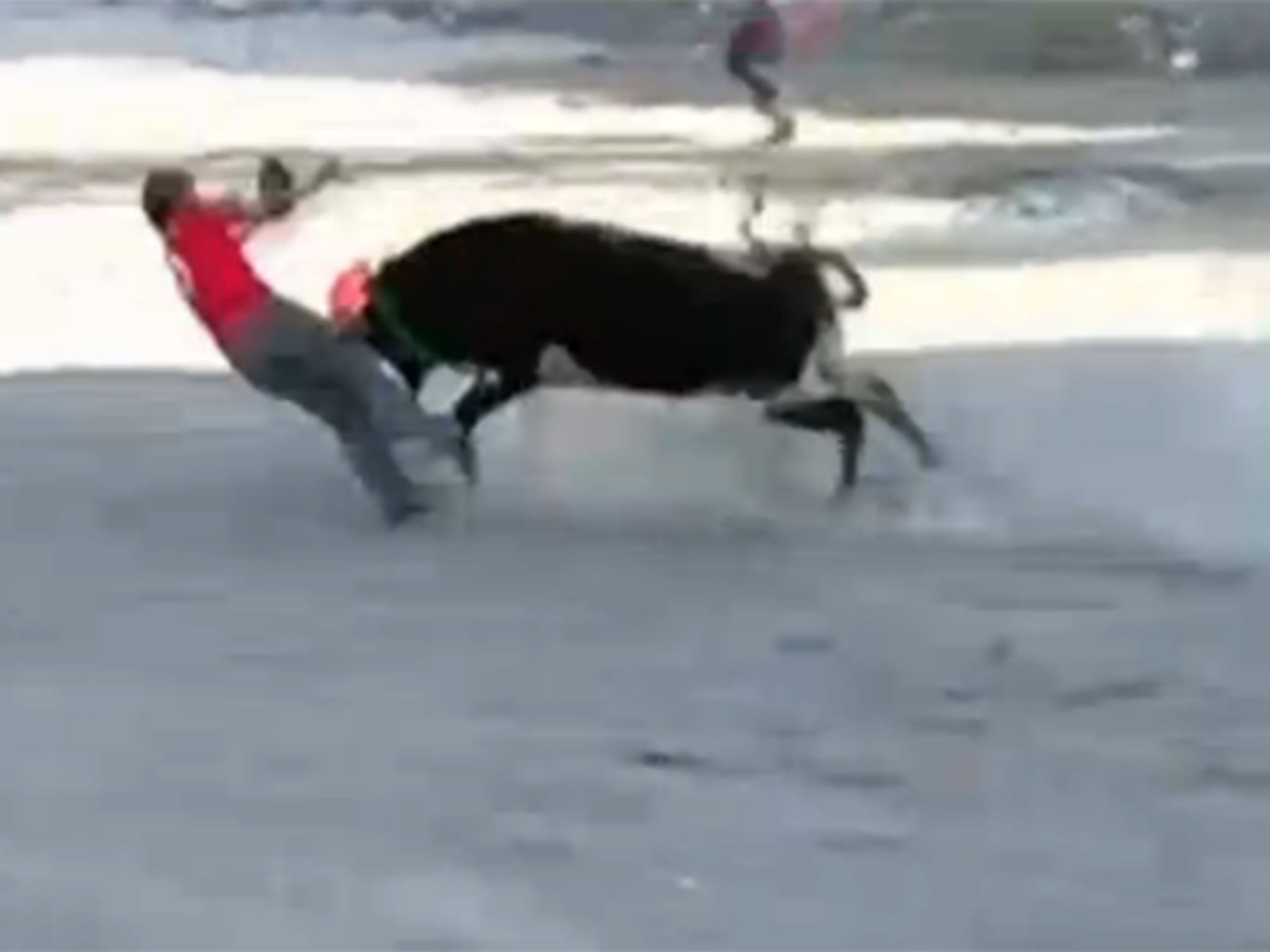 One man is knocked to the ground and attacked by the bull