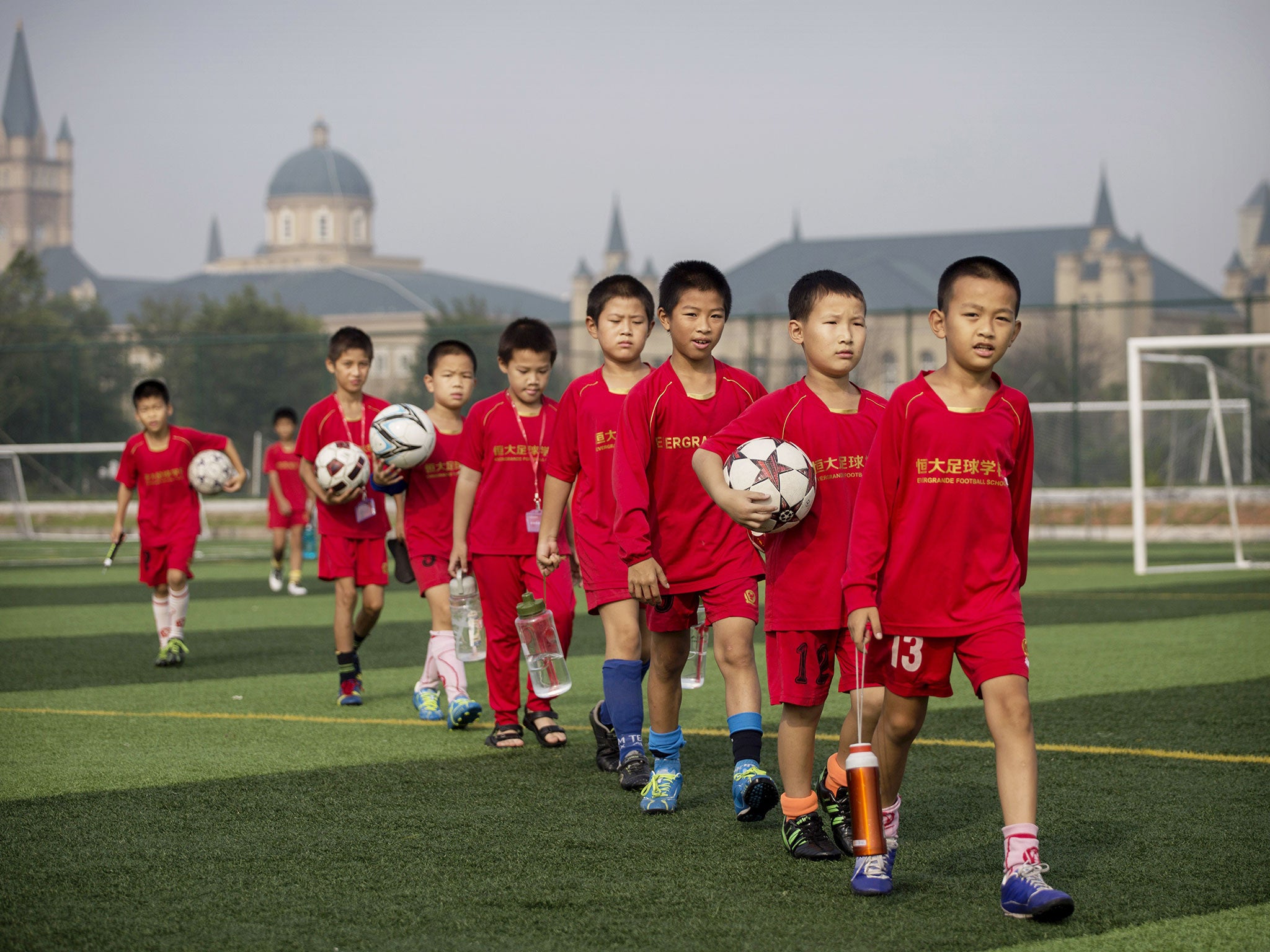 Young Chinese football players walk to training at the Evergrande International Football School near Qingyuan in Guangdong Province