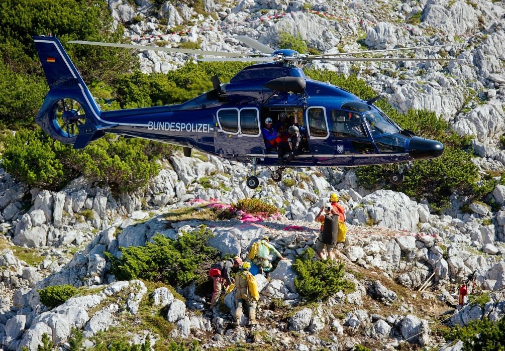 A police helicopter flies aboce rescuers at the Untersberg mountain near Marktschellenberg, Germany, Wednesday June 18, 2014. Germany's mountain rescue service says it could complete the rescue of an injured cave researcher from the country's deepest c