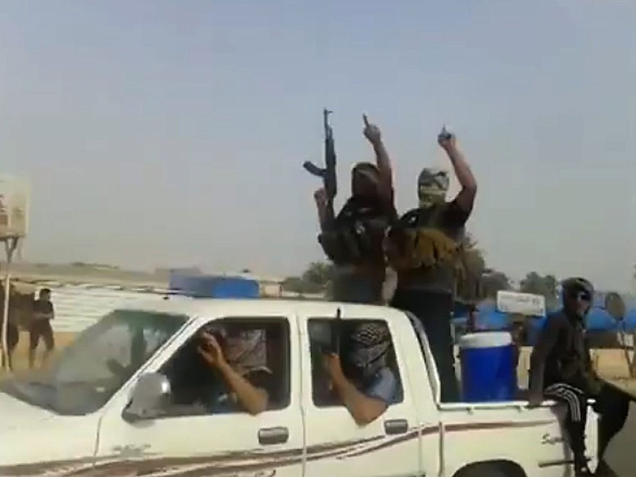 Militants from the Isis group parading with their weapons in the northern city of Baiji in the in Salaheddin province