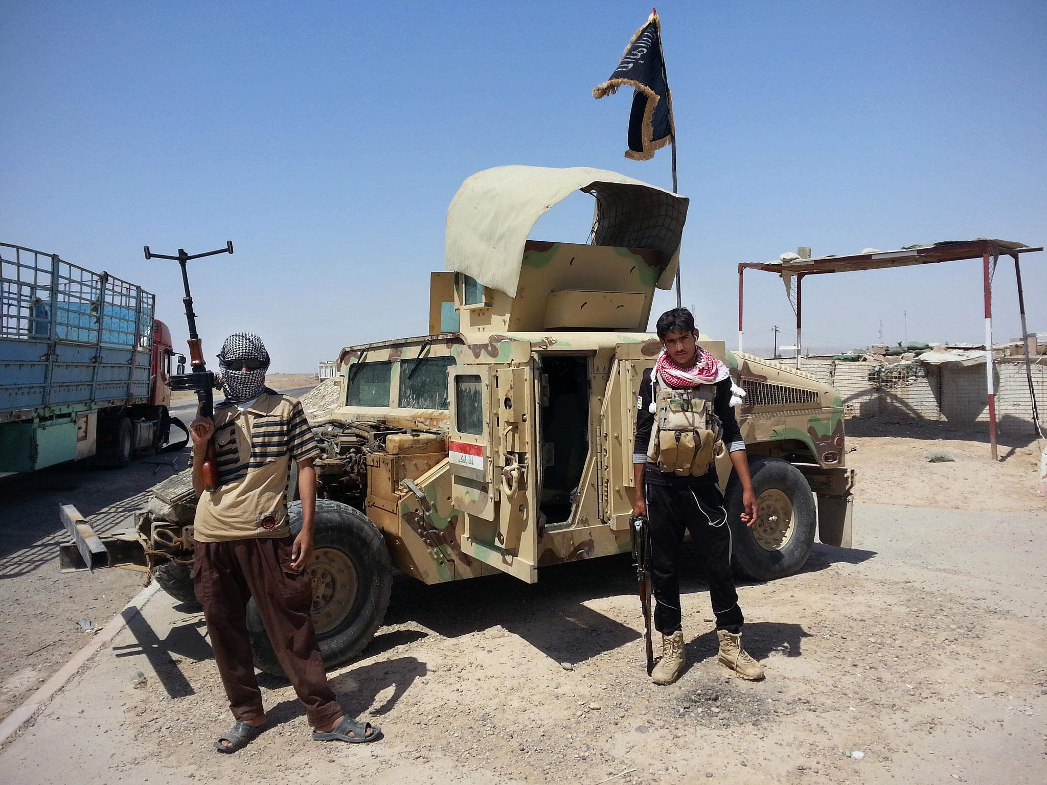 Isis militants with a captured Iraqi army vehicle at a
checkpoint outside the Baiji refinery, north of Baghdad,
yesterday