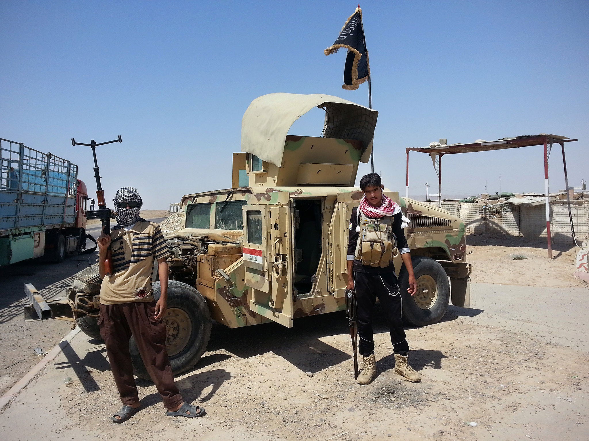 Al-Qa’ida inspired militants stand with captured Iraqi Army Humvee 150 miles north of Baghdad.