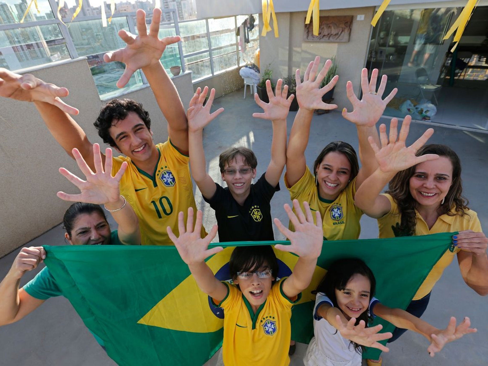 Members of the Silva family, back row, from left, Silvia Santos, Joao de Assis, Pedro de Assis, Ana Carolina Santos and Silvana Santos, front row, Bernardo de Assis, left, and Maria Morena Santos, pose for a photo in their home to show that they each have