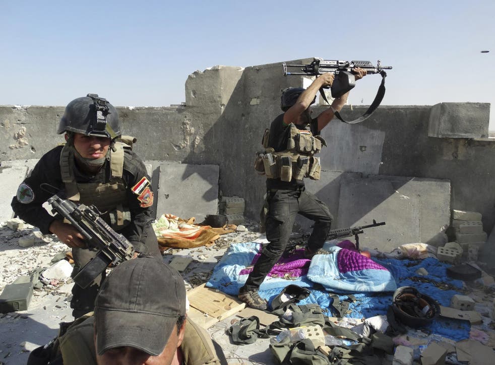 Members of the Iraqi Special Operations Forces take their positions during clashes with the al-Qa'ida-linked Isis