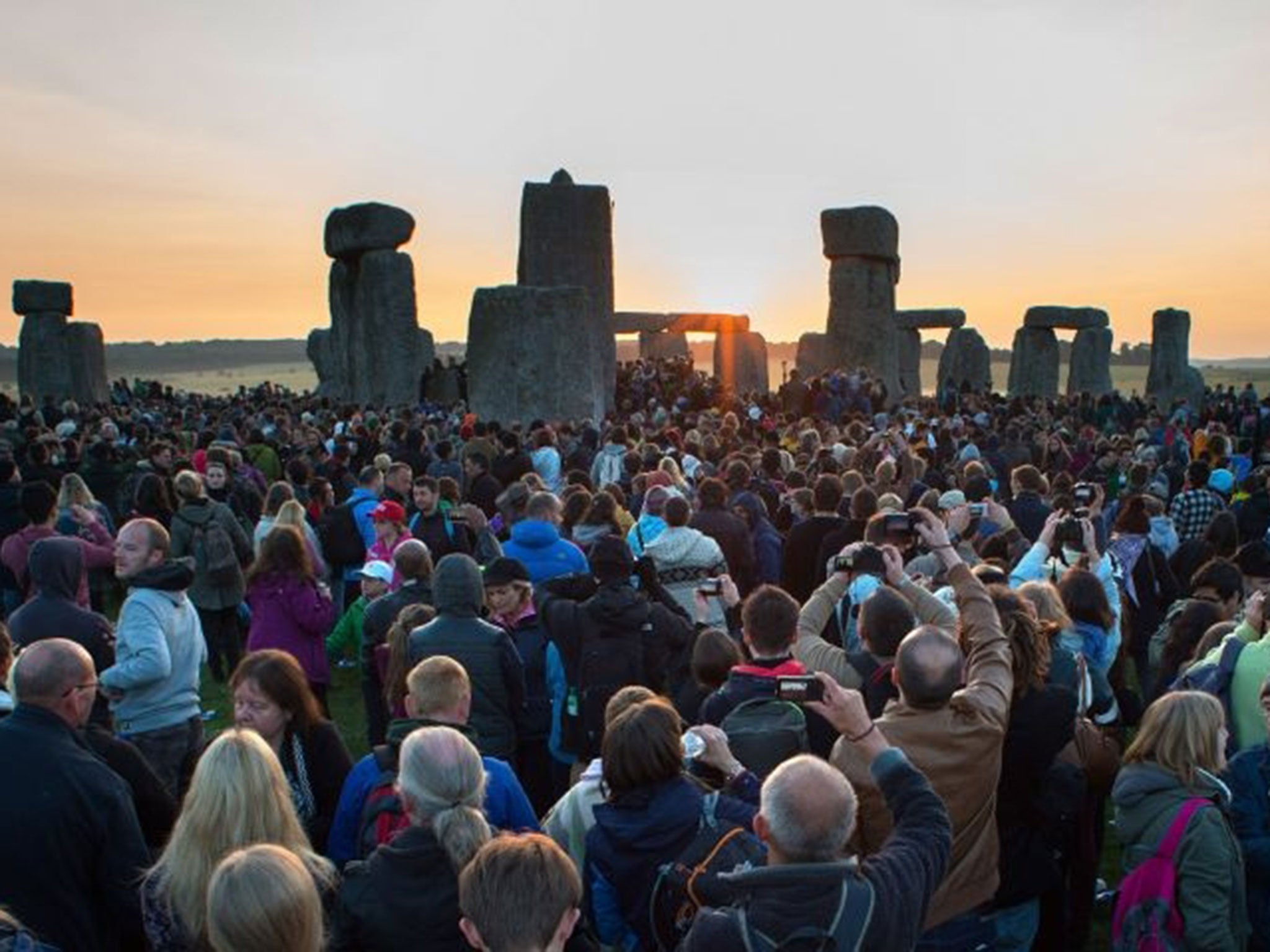 Crowds watch the glorious sunrise at Stonehenge on the Summer Solstice