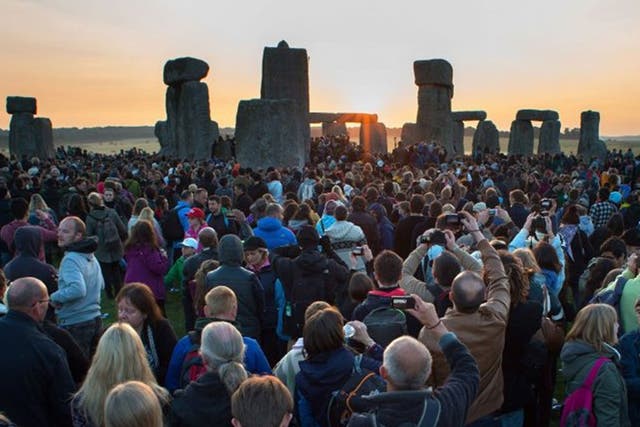 Crowds watch the glorious sunrise at Stonehenge on the Summer Solstice