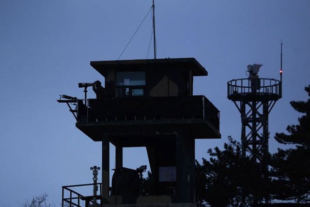 A South Korean soldier (unlinked to the shooting) uses binoculars to look out to sea from a watchtower on the Yeonpyeong island, which lies just inside the South Korean side of the Northern Limit Line (NLL) in the Yellow Sea 