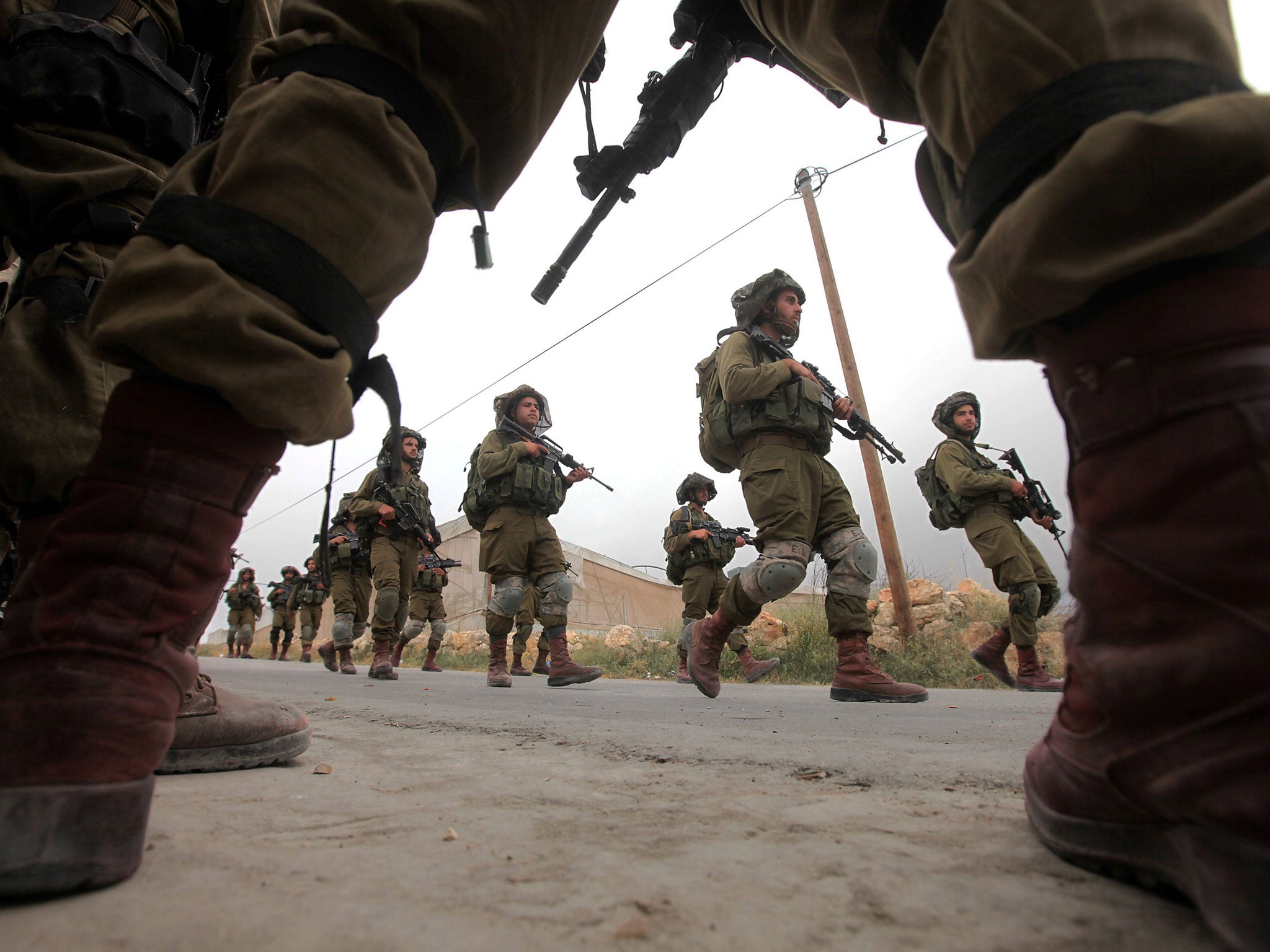 Israeli soldiers on patrol near the West Bank city of Hebron, as searches continue for three missing Israeli teenagers who are presumed to have been kidnapped