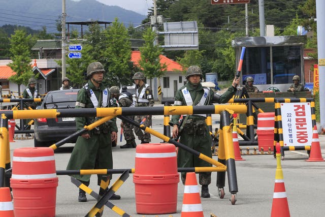 Soldiers guard the road during the search for a conscript who fled after killing five comrades at a temporary checkpoint in Goseong, South Korea