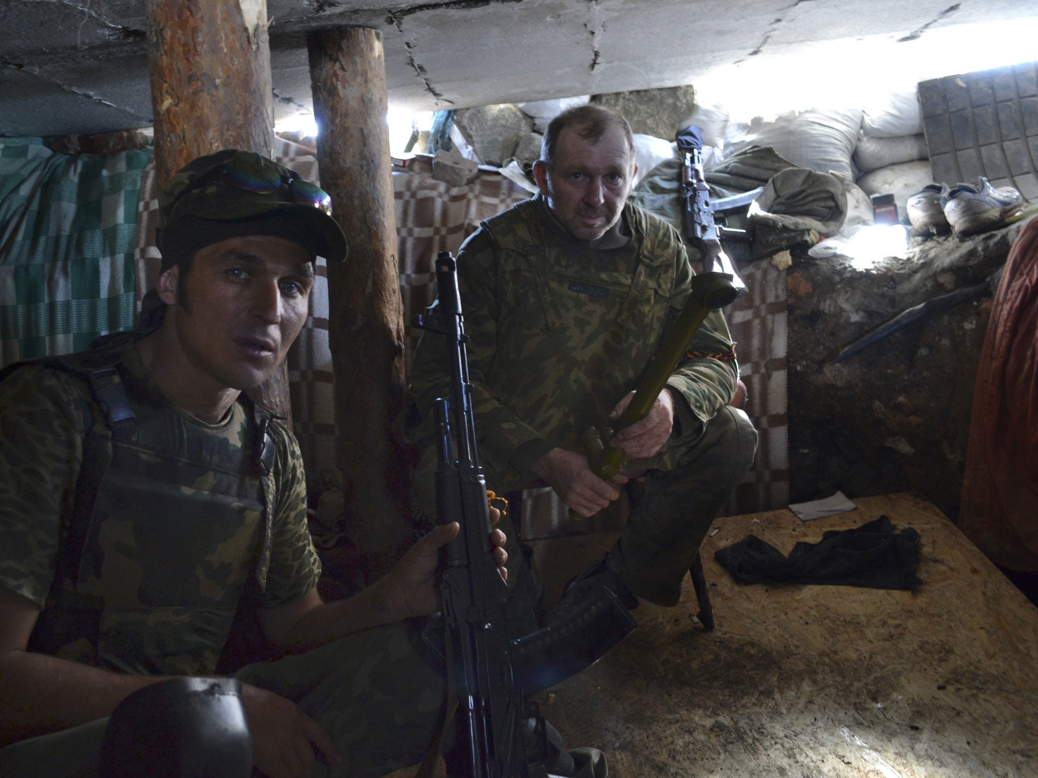 Pro-Russian fighters rest in a shelter at their position outside Slovyansk, eastern Ukraine, Sunday, June 22, 2014. Russian president Vladimir Putin said Sunday that fighting was continuing, including what he said was artillery fire from the Ukrainian side. Poroshenko has said his troops reserve the right to fire back if separatists attack them or civilians