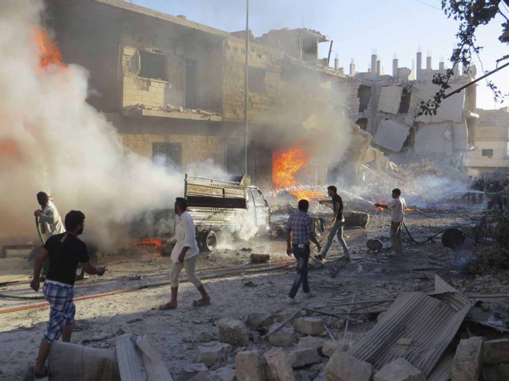 Men try to put out a fire at a site hit by what activists said was an airstrike by forces loyal to Assad, in Idlib