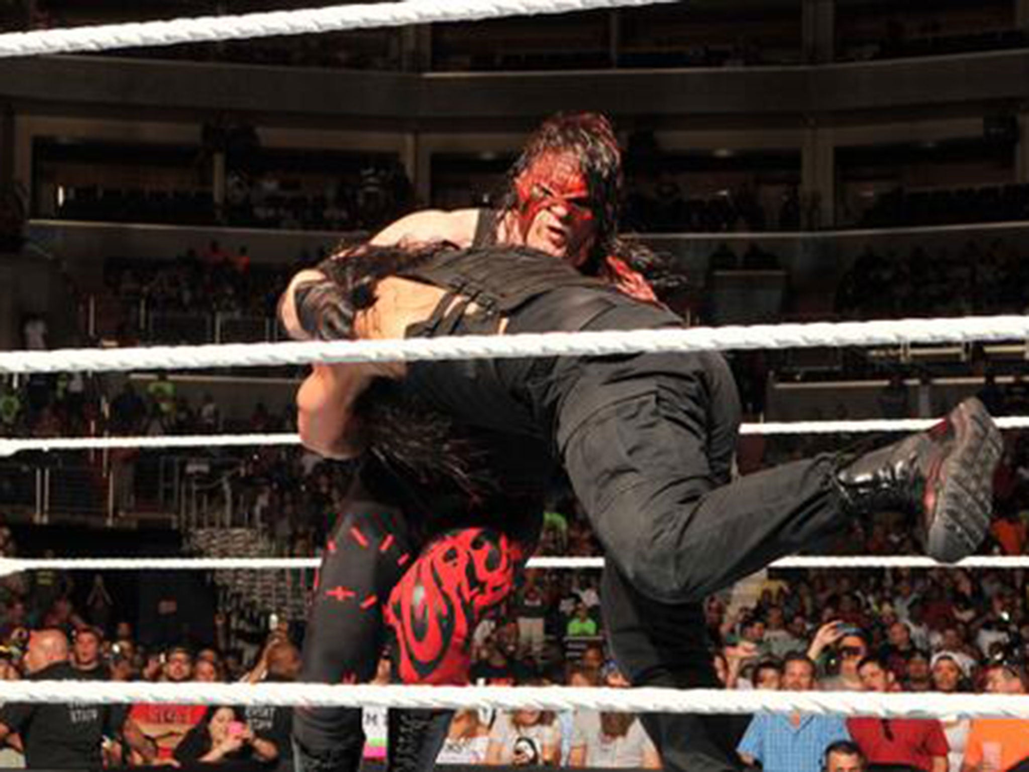 Roman Reigns hits Kane with a spear