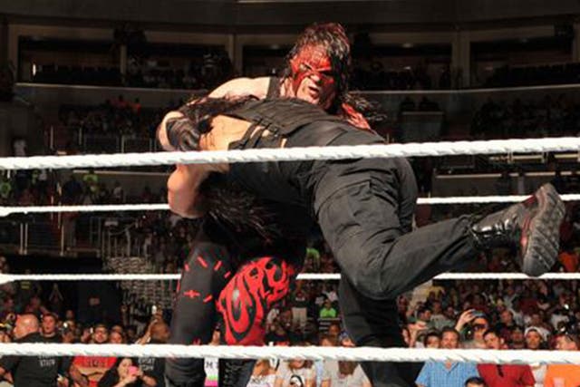 Roman Reigns hits Kane with a spear