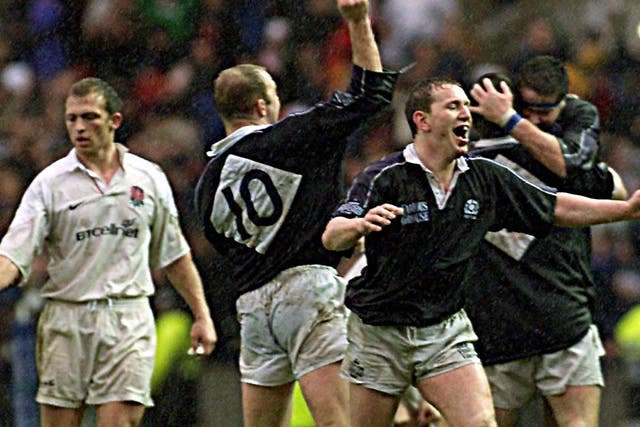 England's captain Matt Dawson (left) walks towards the jubilating Scottish captain Andy Nicol (foreground) with Duncan Hodge (No.10) after they beat England