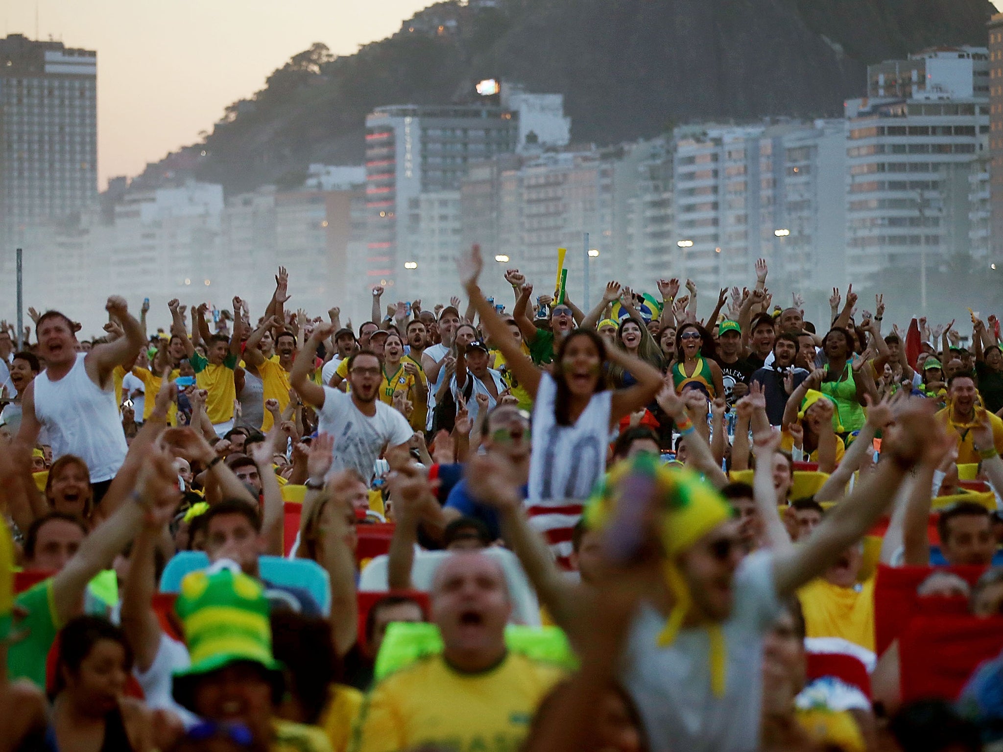 Brazil fans on Copacabana Beach cheer after Brazil scored its first goal while watching a live broadcast of the Brazil-Cameroon match