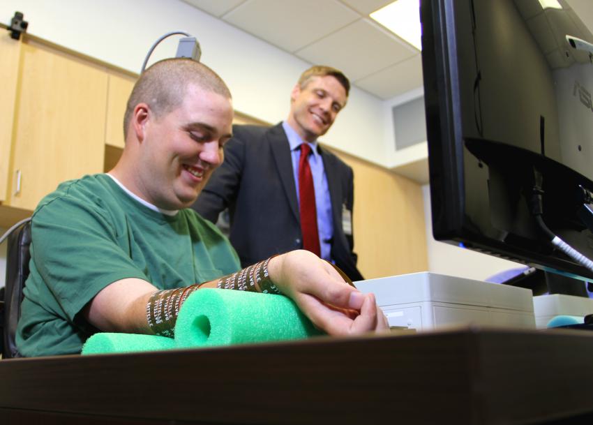 Ian Burkhart (left) and Chad Bouton (right), research leader from Battelle. Bouton and his team at Battelle pioneered the Neurobridge technology, working closely with doctors from The Ohio State University Wexner Medical Center, which allowed Burkhart to become the first patient ever to move his paralyzed hand with his own thoughts.