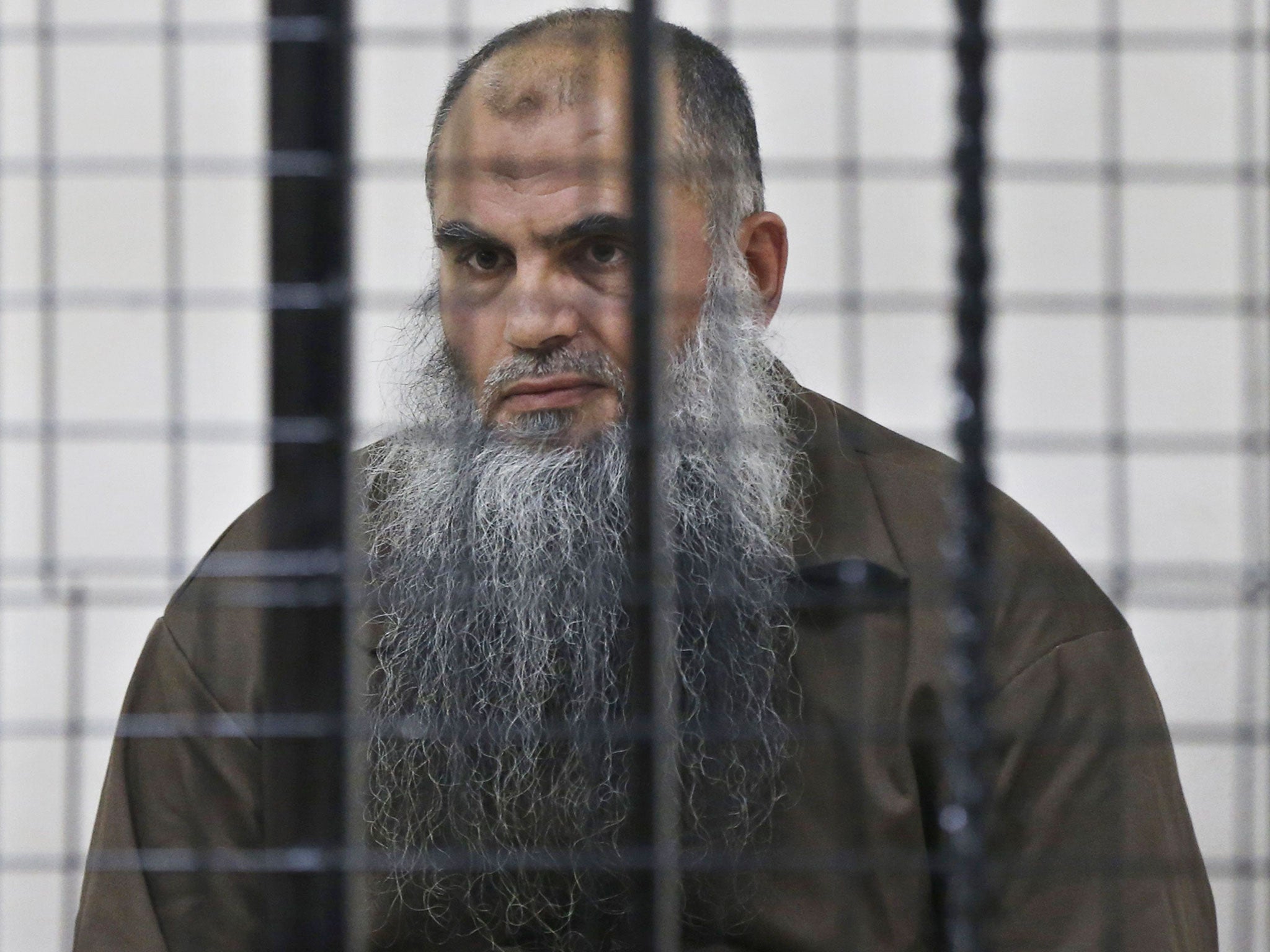 Radical Muslim cleric Abu Qatada looks on from behind bars at the State Security Court in Amman