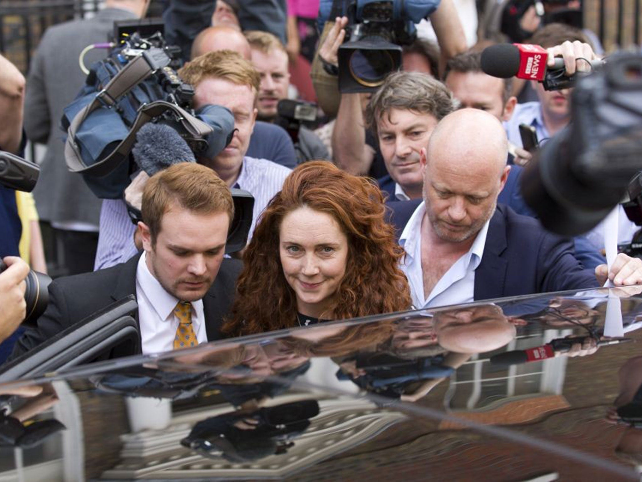 Former News International chief executive Rebekah Brooks is escorted through a crowd of journalists in London with her husband Charlie behind her as she leaves Southwark Crown Court having been found not guilty on all charges