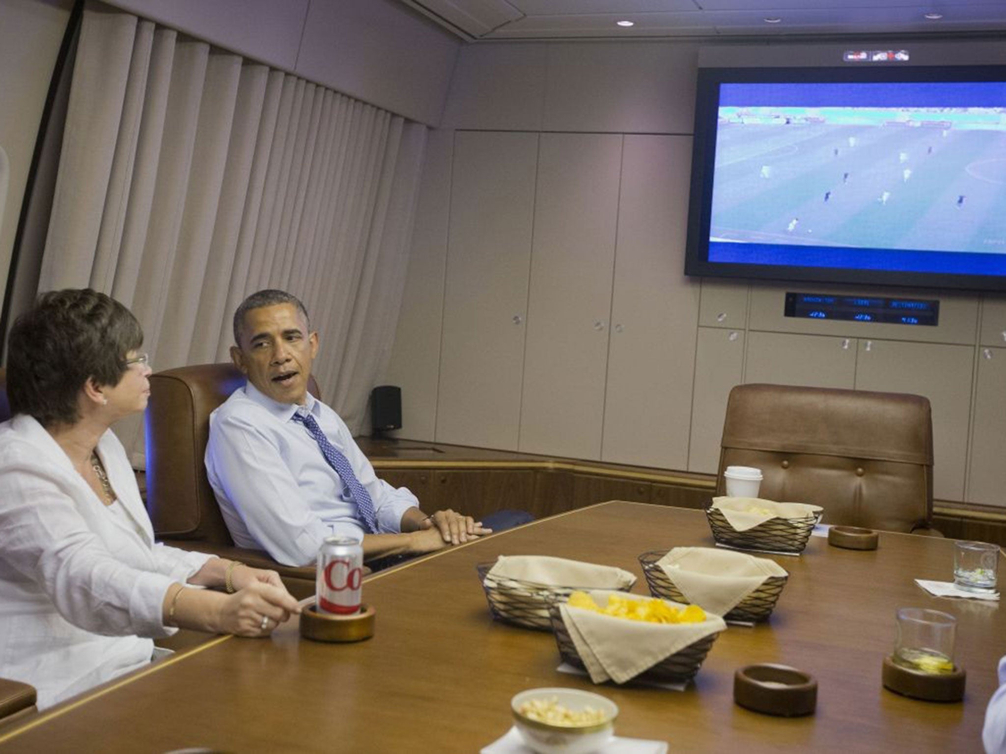 US President Barack Obama and Senior Advisor Valerie Jarrett (L) watch the 2014 World Cup match between the US and Germany while en route to Minnepolis