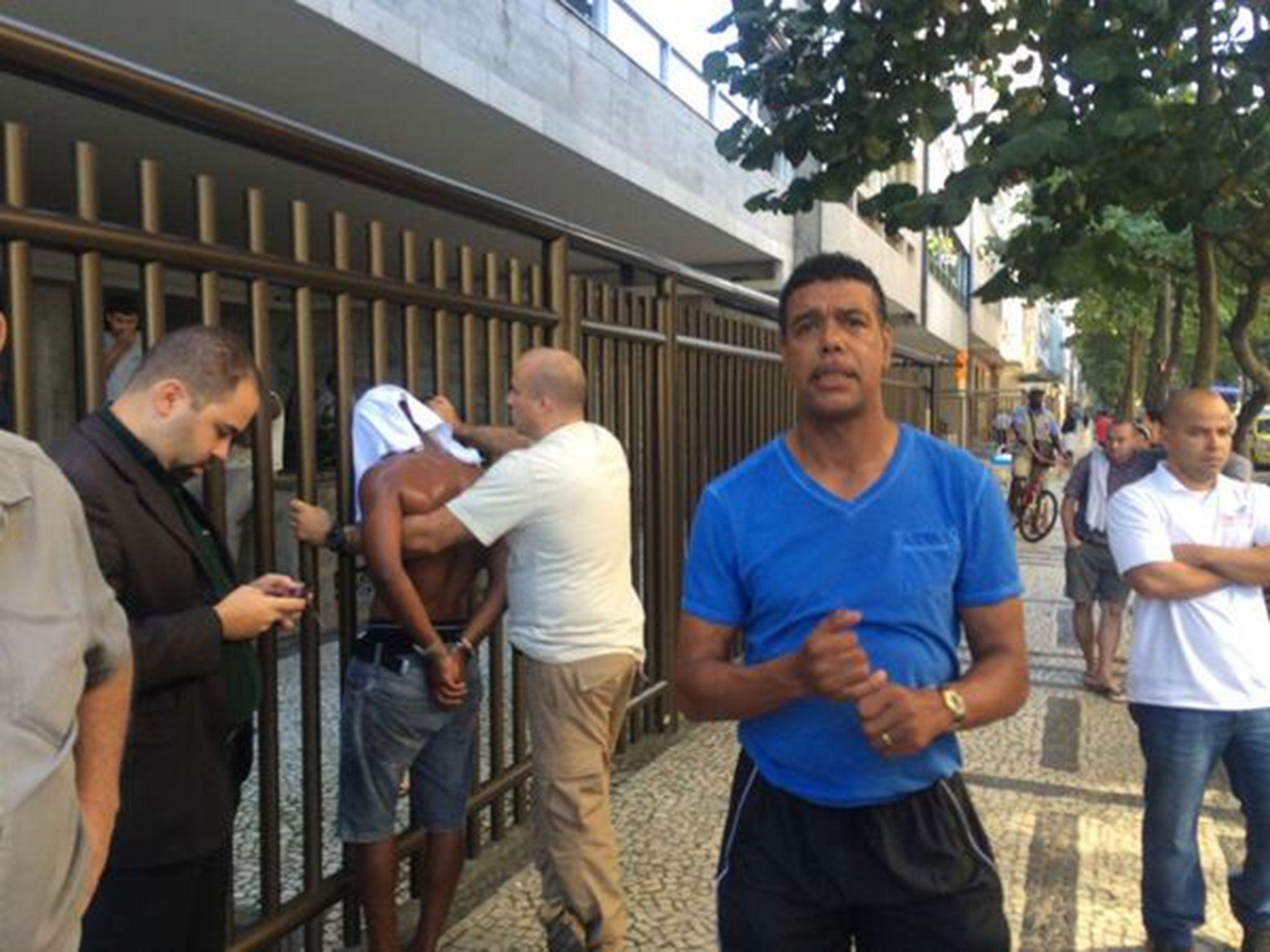 Chris Kamara poses in front of a robber that he chased and caught in Brazil