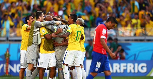 Brazil players mob Julio Cesar after he saved two penalties to send Braizl into the quarter-finals