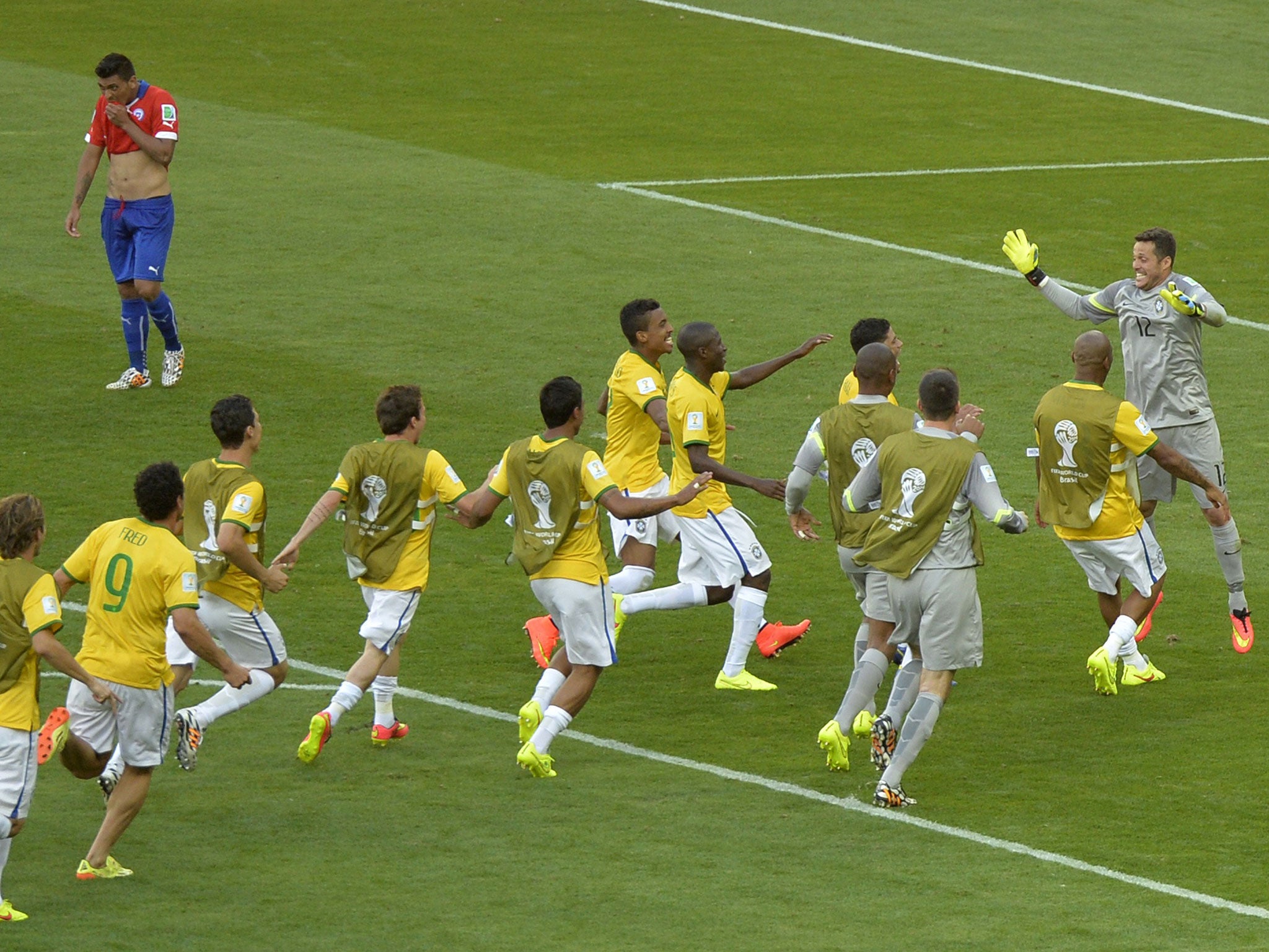 Players rush to celebrate with the hero after Gonzalo Jara hits the post