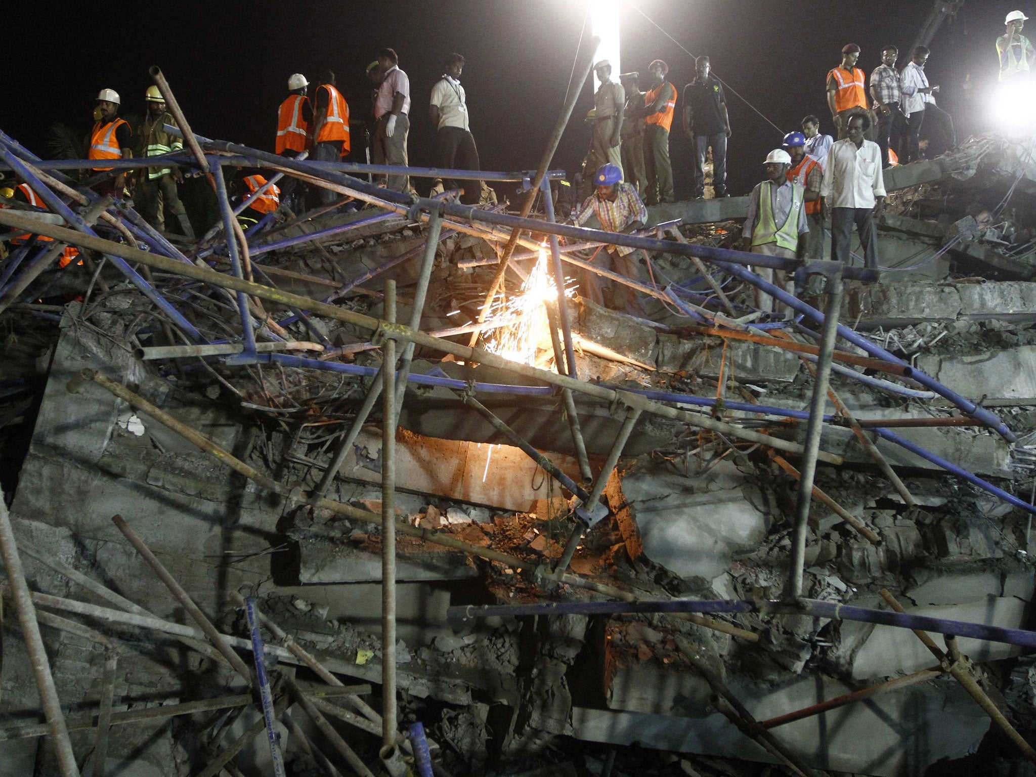 Rescue workers conduct a search operation for survivors at the site of a collapsed 11-storey building that was under construction on the outskirts of the southern Indian city of Chennai