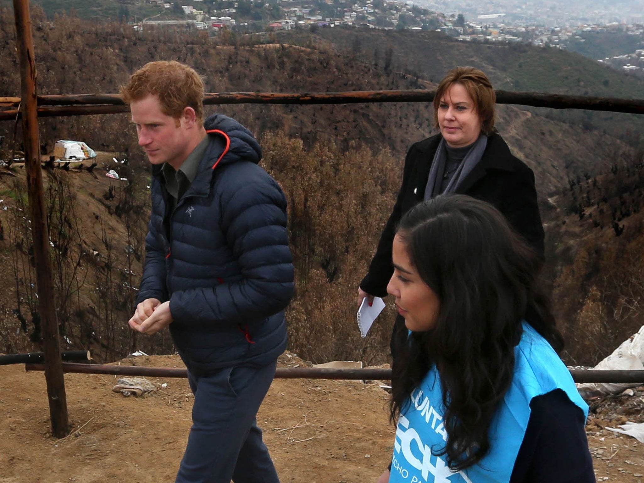Prince Harry is shown the devastation left by the Valparaiso fire that burnt down many homes in the poorest area of the town