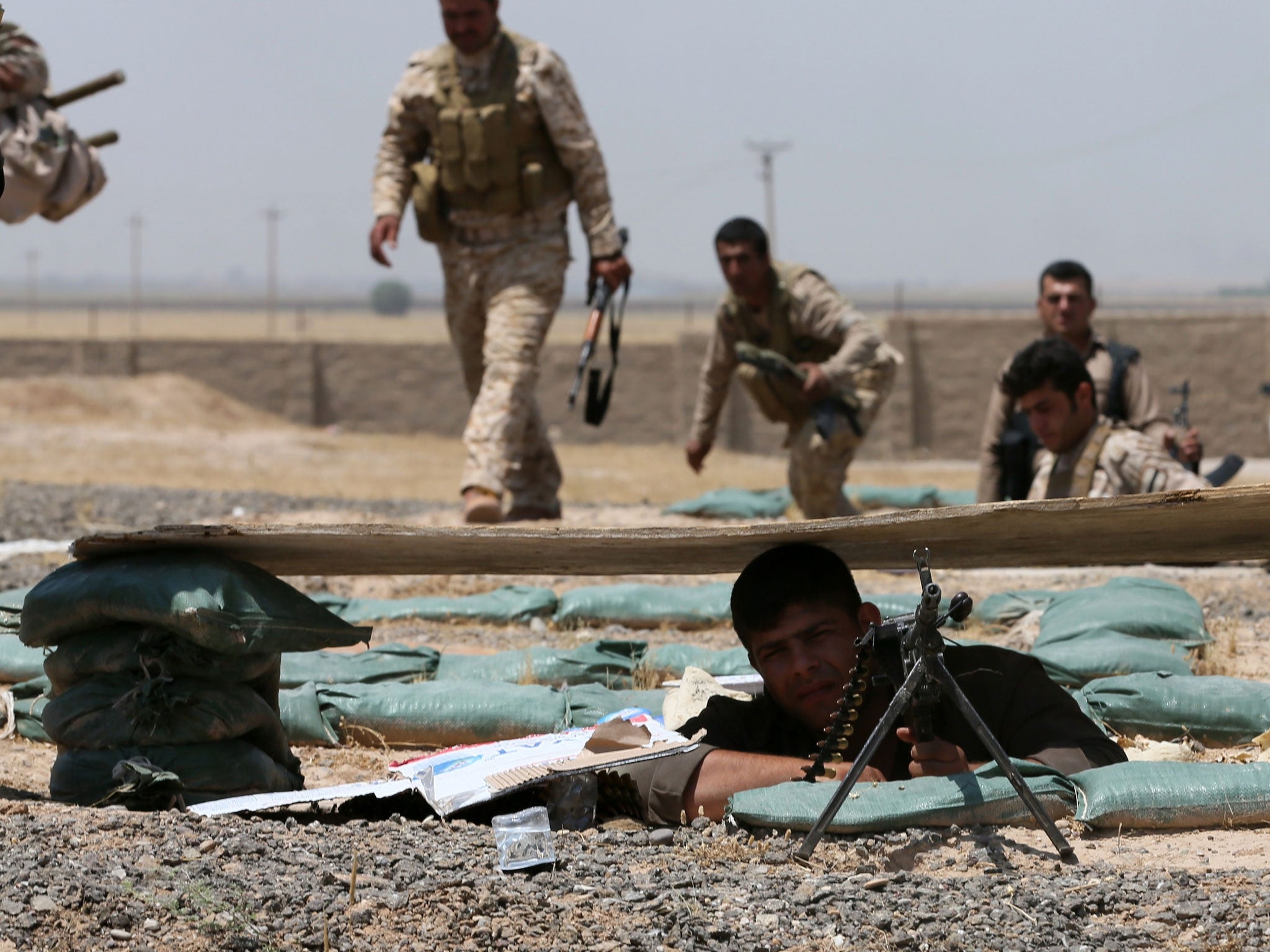 Iraqi Kurdish forces take position as they fight jihadist militants on 29 June in the Iraqi village of Bashir, 20km south of the city of Kirkuk