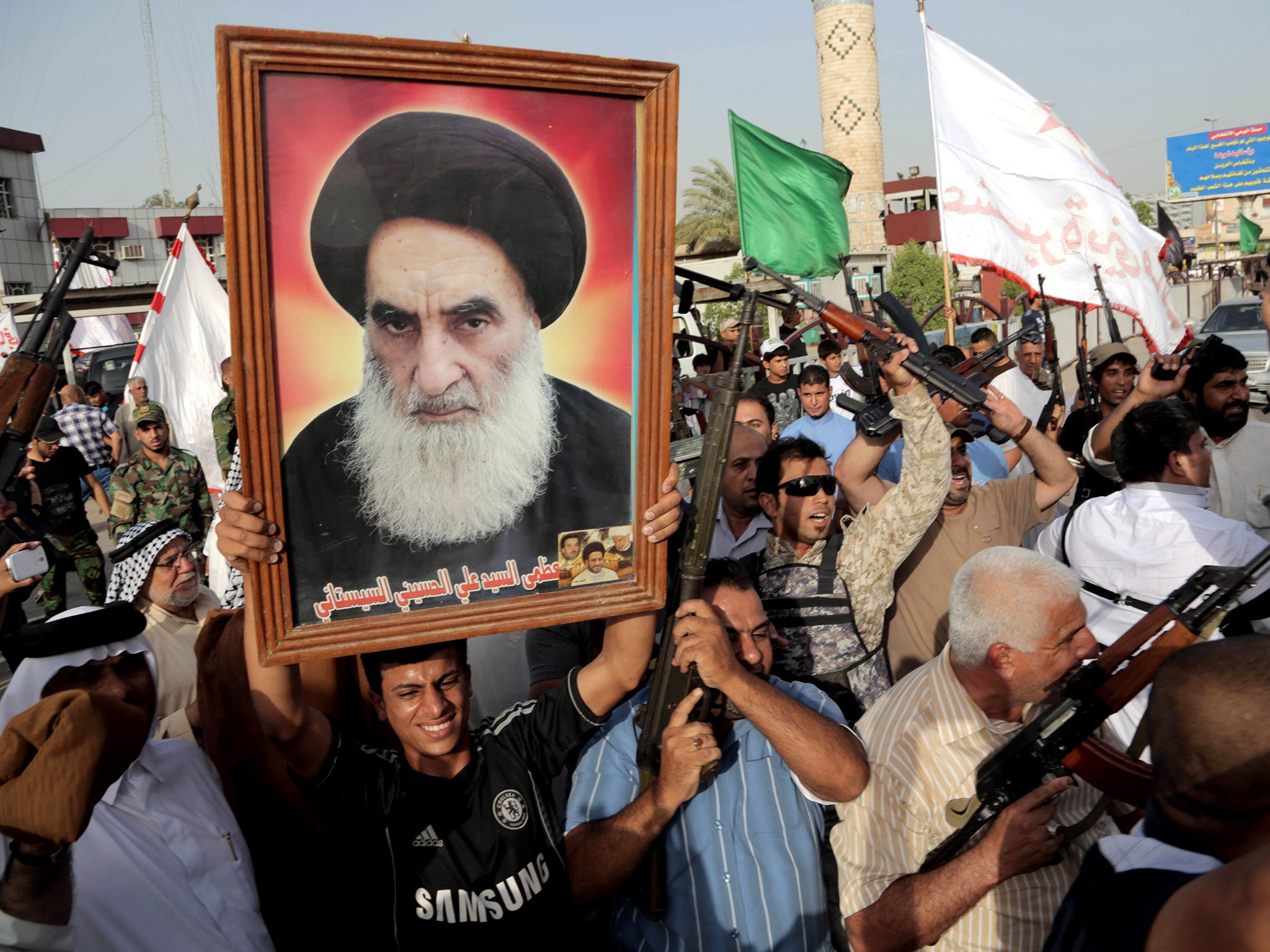 Iraqi Shia fighters hold a portrait of Grand Ayatollah Ali al-Sistani, who has called on Prime Minister Nouri al-Maliki to step down