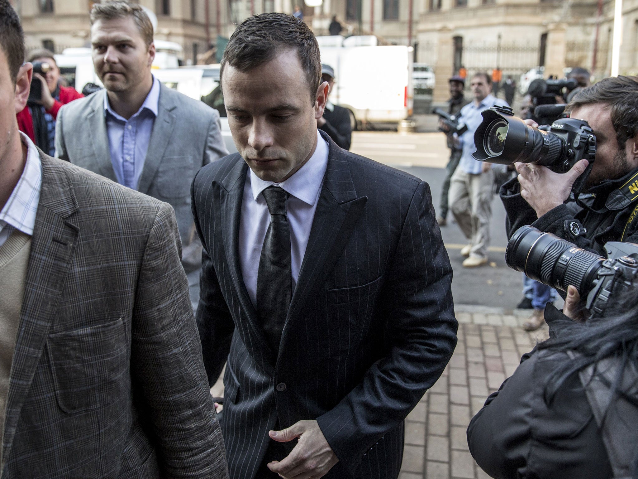 South African Paralympian Oscar Pistorius (C) arrives in Court in Pretoria on June 30, 2014. After a six-week break, the murder trial that has gripped South Africa and the world resumes on June 30 when Paralympian Oscar Pistorius returns to the dock after