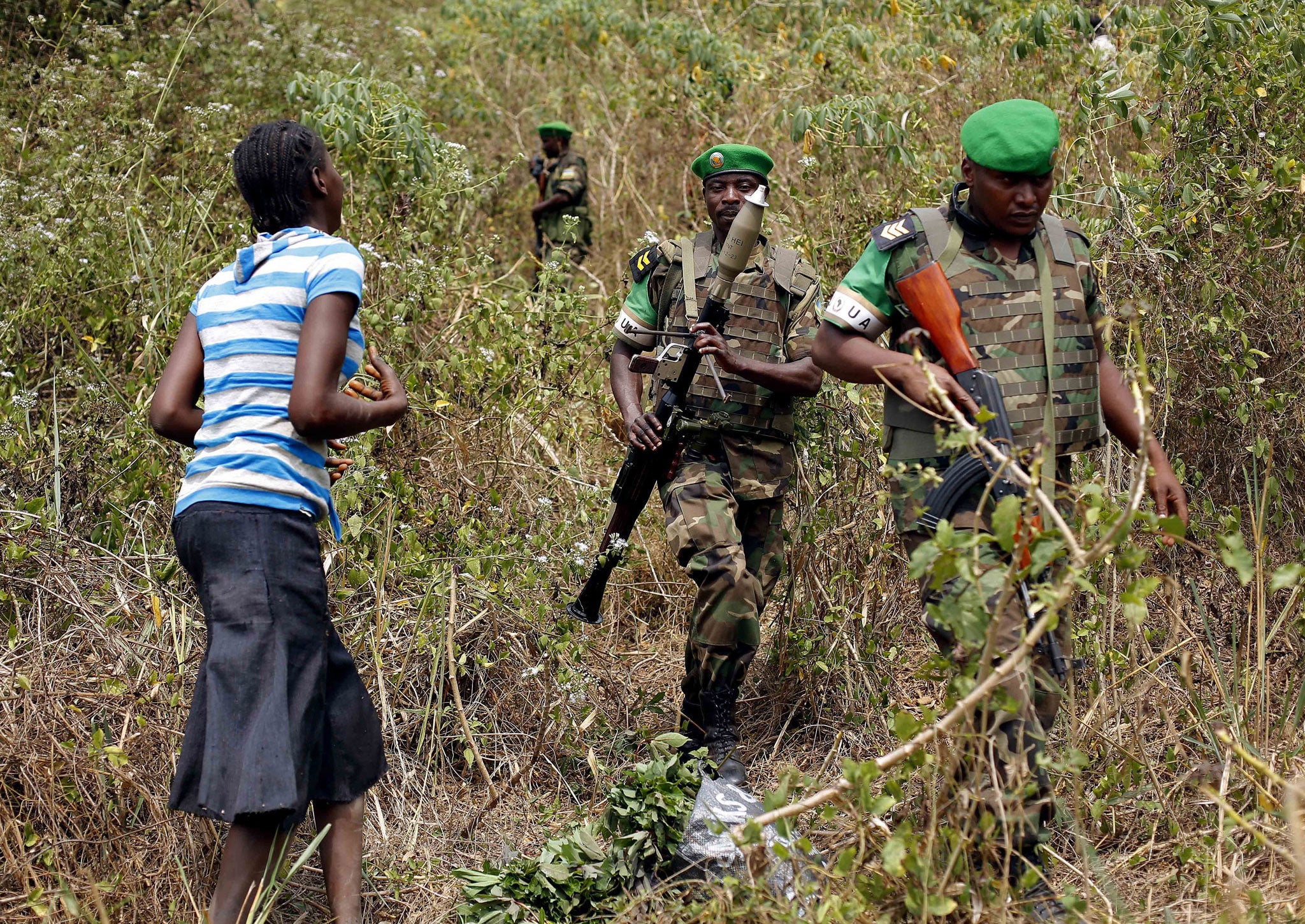 A terrified woman walks down from the bush in the hills 15 kilometers (9 miles) outside Bangui as Rwandan troops tell her to calm down during a weapons search operation