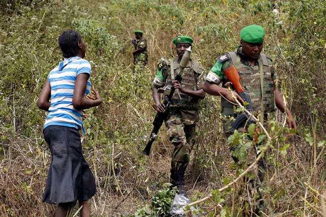 A terrified woman walks down from the bush in the hills 15 kilometers (9 miles) outside Bangui as Rwandan troops tell her to calm down during a weapons search operation