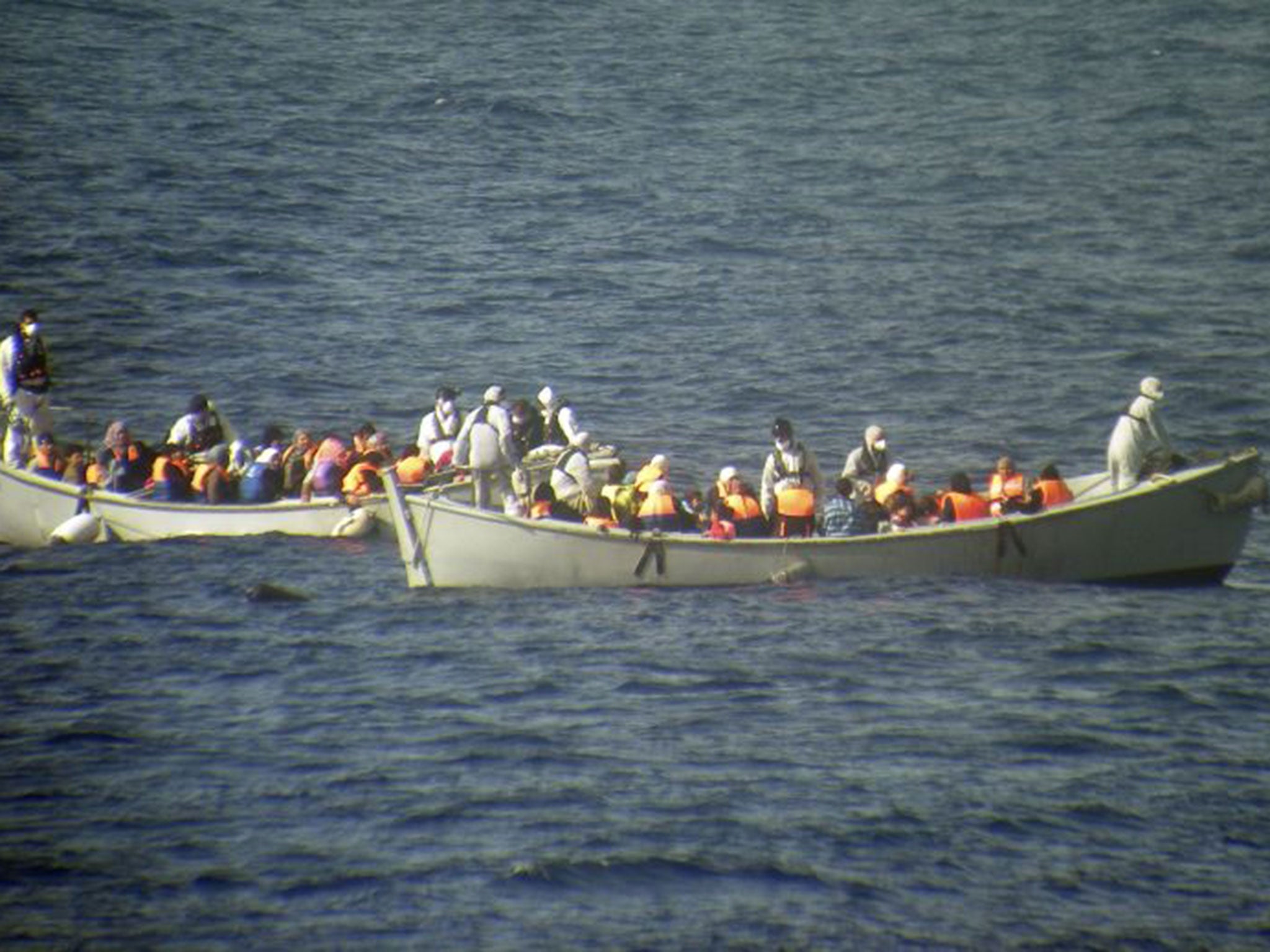 Two lifeboats from the frigate Grecale carry a group of the rescued migrants. 30 bodies were found in the hold of the packed smugglers' boat