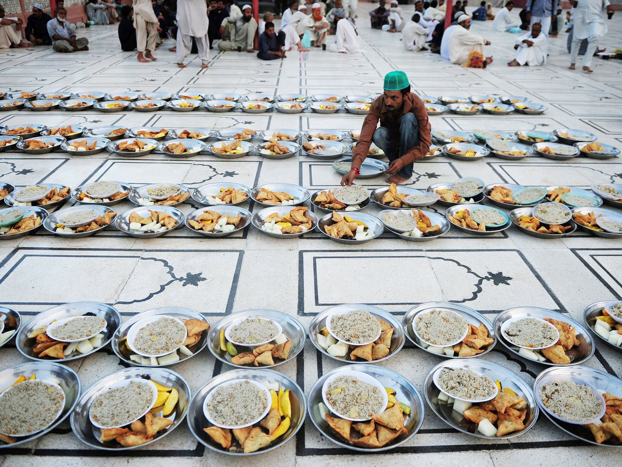 A Pakistani Muslim man arranges Iftar food for Muslim devotees