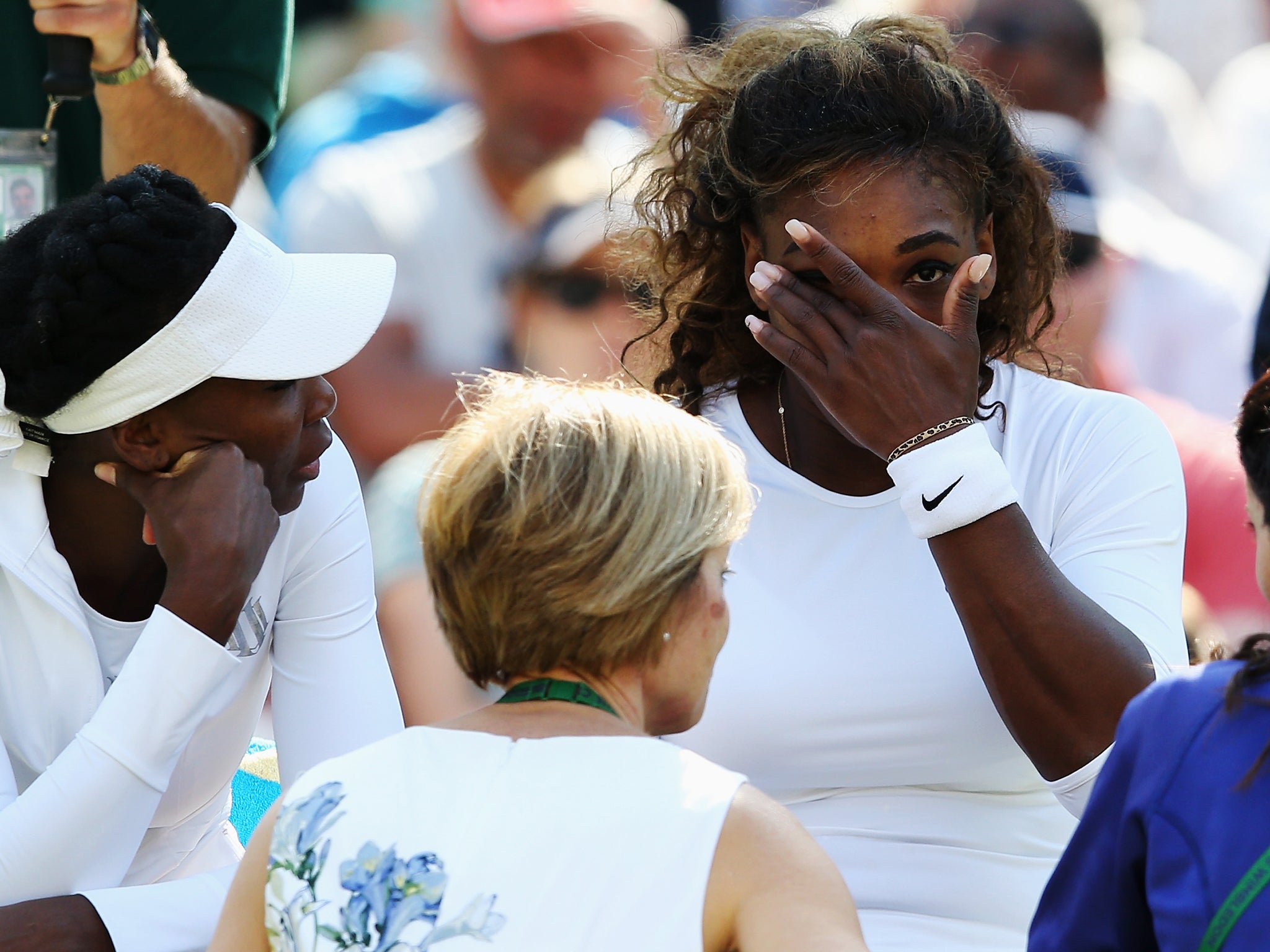 Serena Williams receives treatment during the warm up before her second round doubles match with sister Venus before retiring