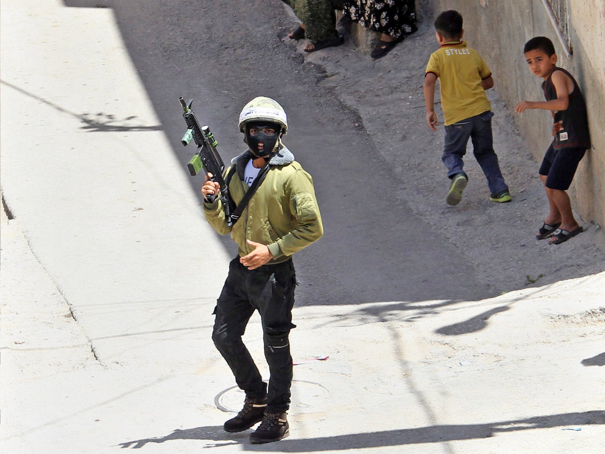 A Palestinian militant holds his gun near the funeral of Yousef Abu Zagha in Jenin