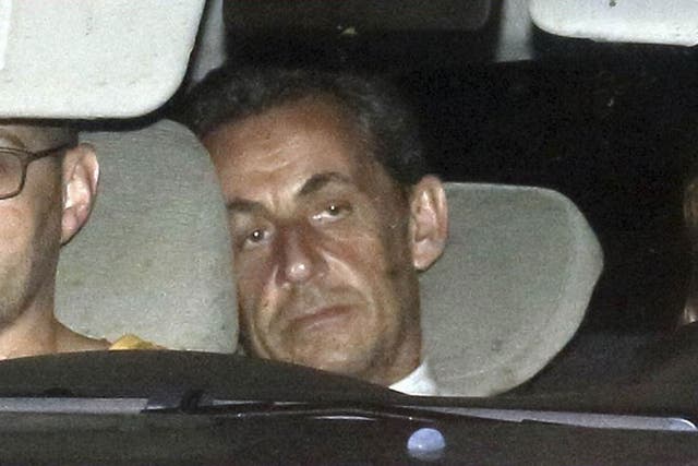 Nicolas Sarkozy arrives with police by car at the financial investigation unit in Paris to be presented to a judge
