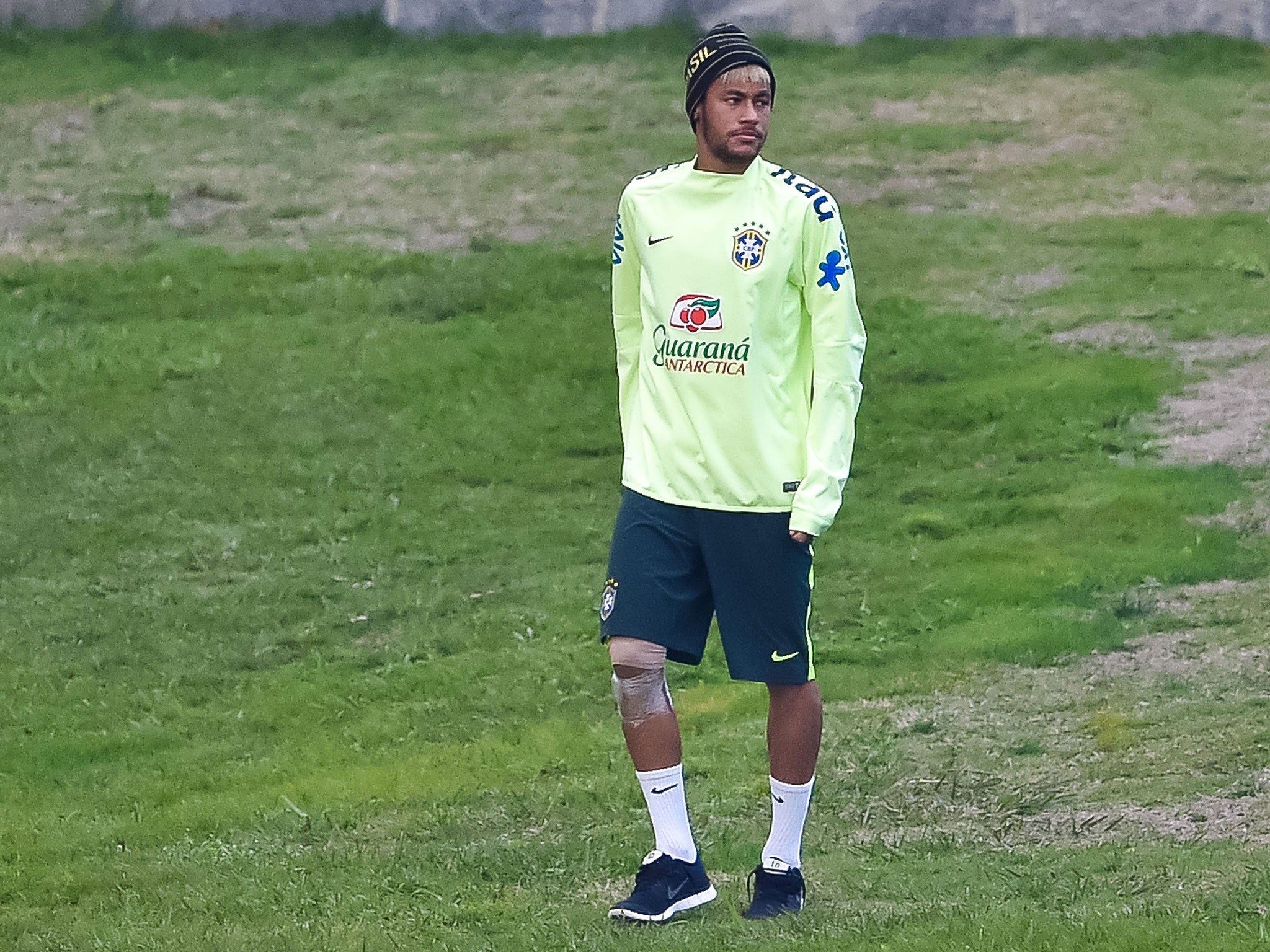 Neymar attends a Brazil training session with him right knee strapped up