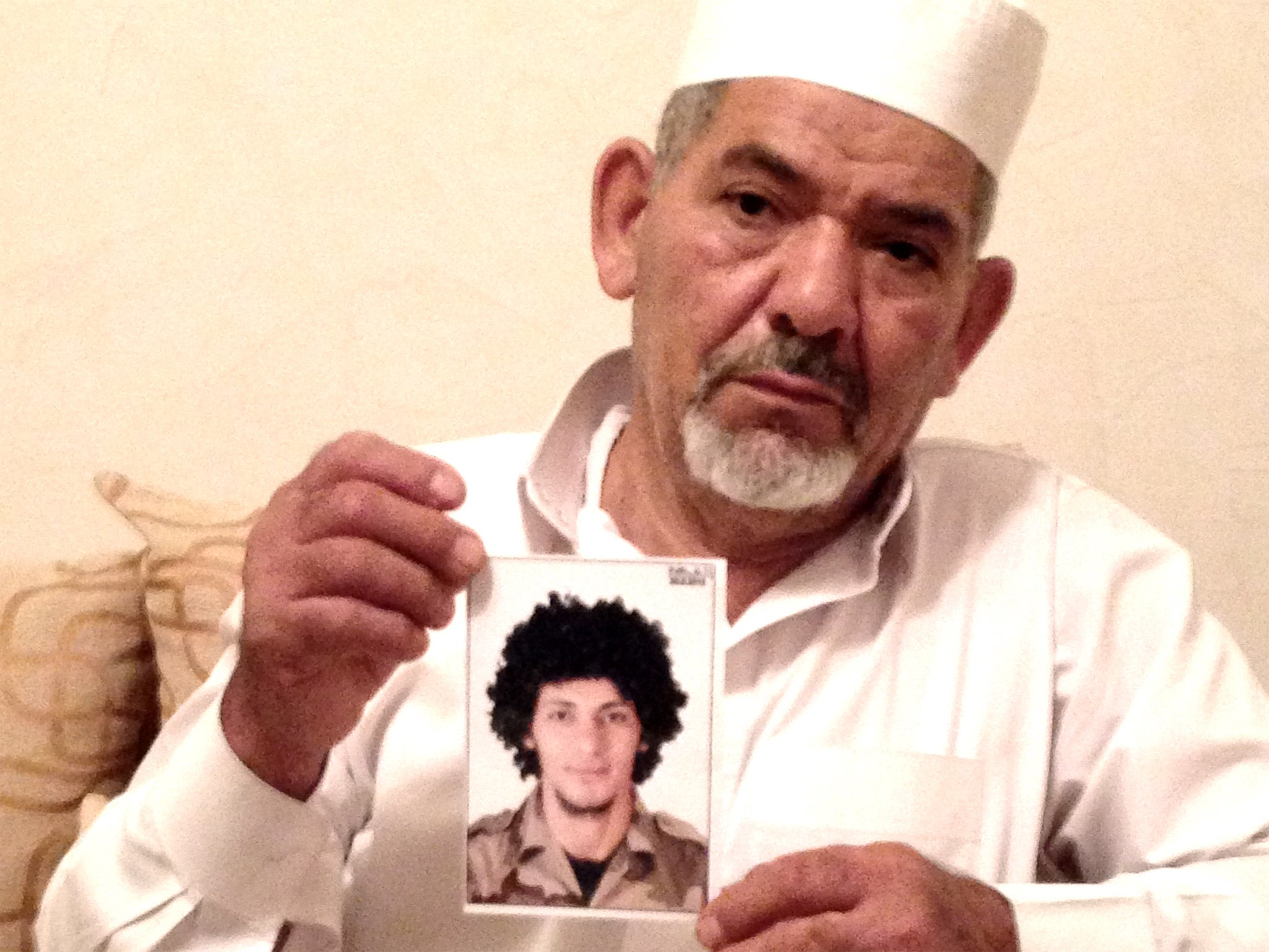 Ramadan al-Hallouj holds a photo of his dead son, Khalid