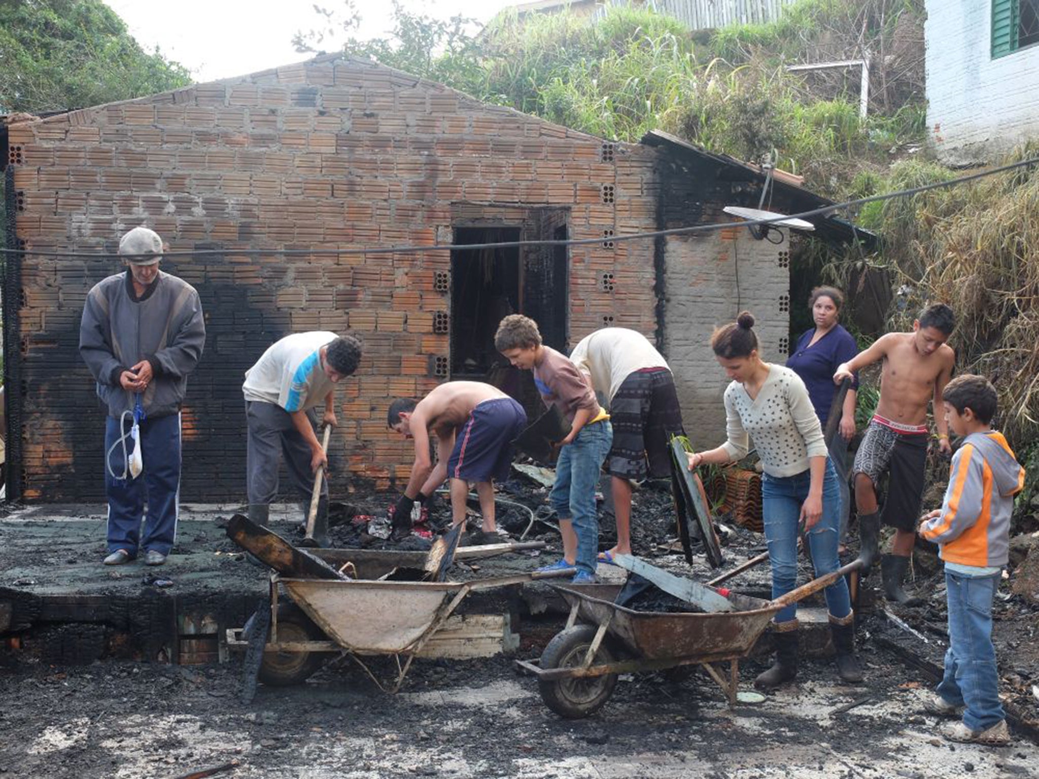 Pedro Miguel Gomes and his family clear up his burnt-out house