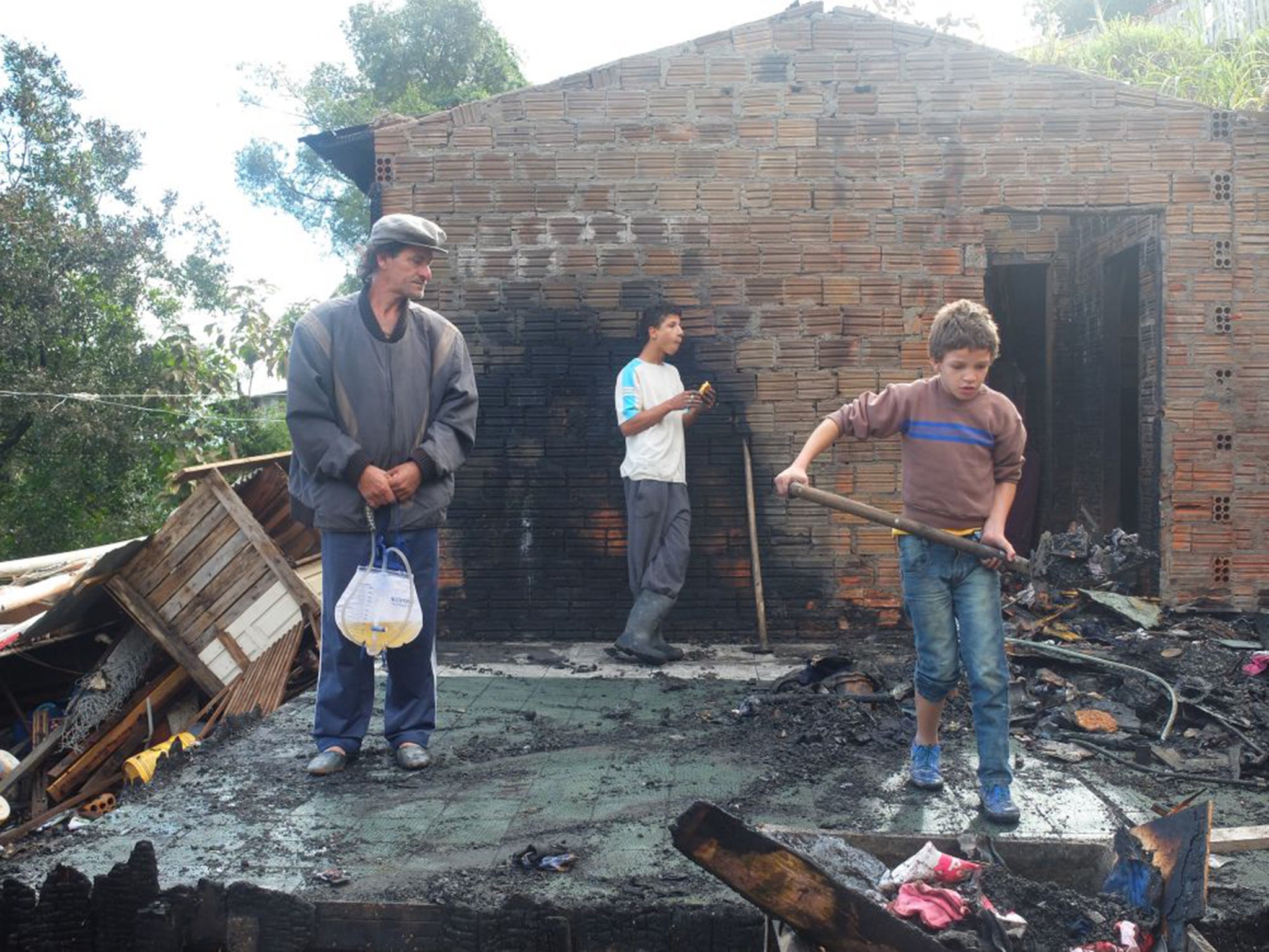 Pedro Miguel Gomes and his family clear up his burnt-out house