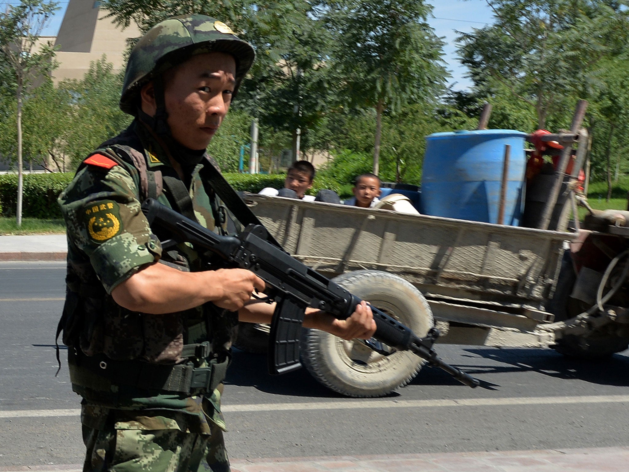 Chinese paramilitary police man a checkpoint on the road to the riot-affected Uighur town of Lukqun, Xinjiang province, on June 28, 2013, after a flare-up of violence