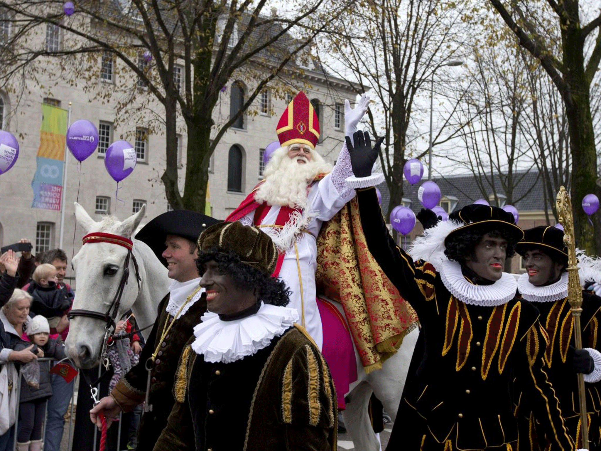 Sinterklaas, the Dutch version of Santa Claus, center, and his blackface sidekick "Zwarte Piet", or Black Pete, in Amsterdam.