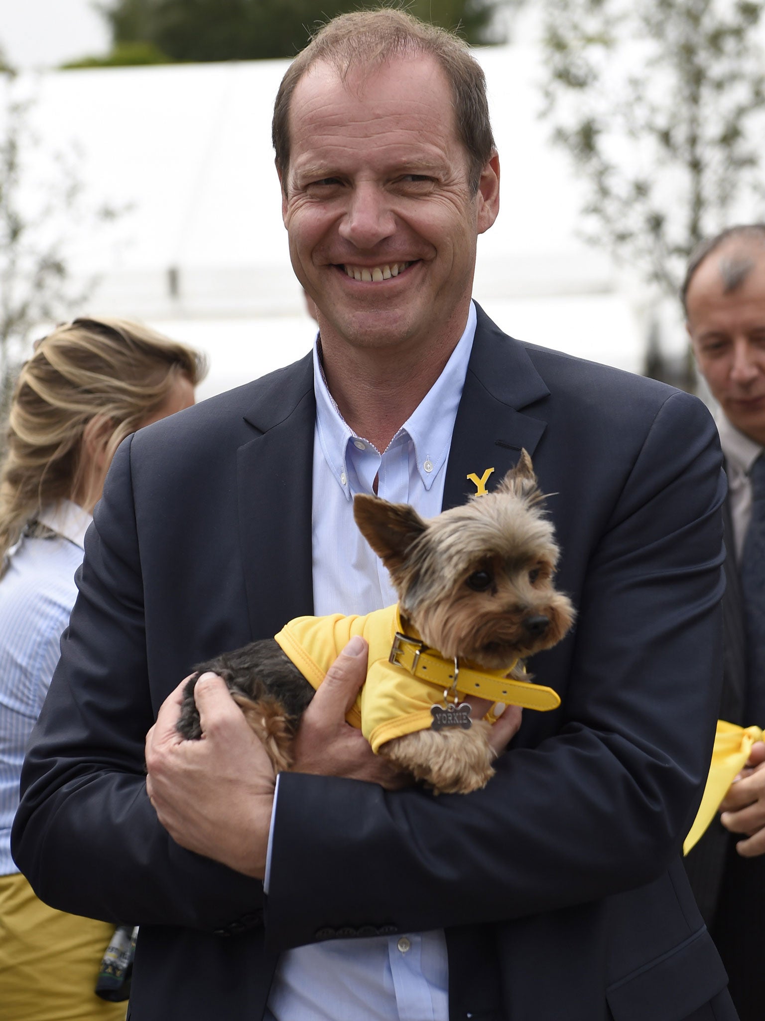 General director of the Tour de France, Christian Prudhomme, holds a Yorkshire Terrier