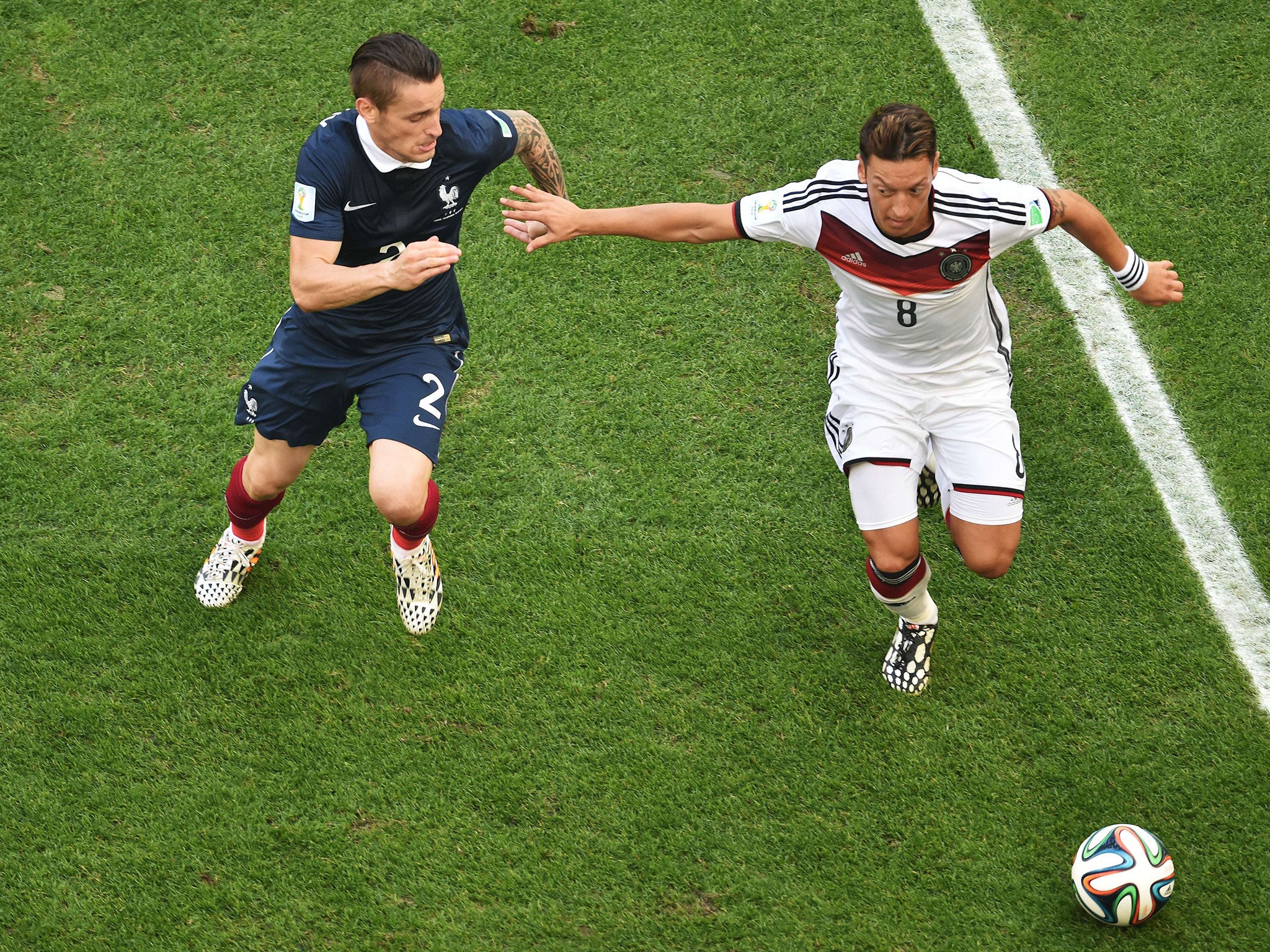 France's defender Mathieu Debuchy (L) tackles Germany's midfielder Mesut Ozil