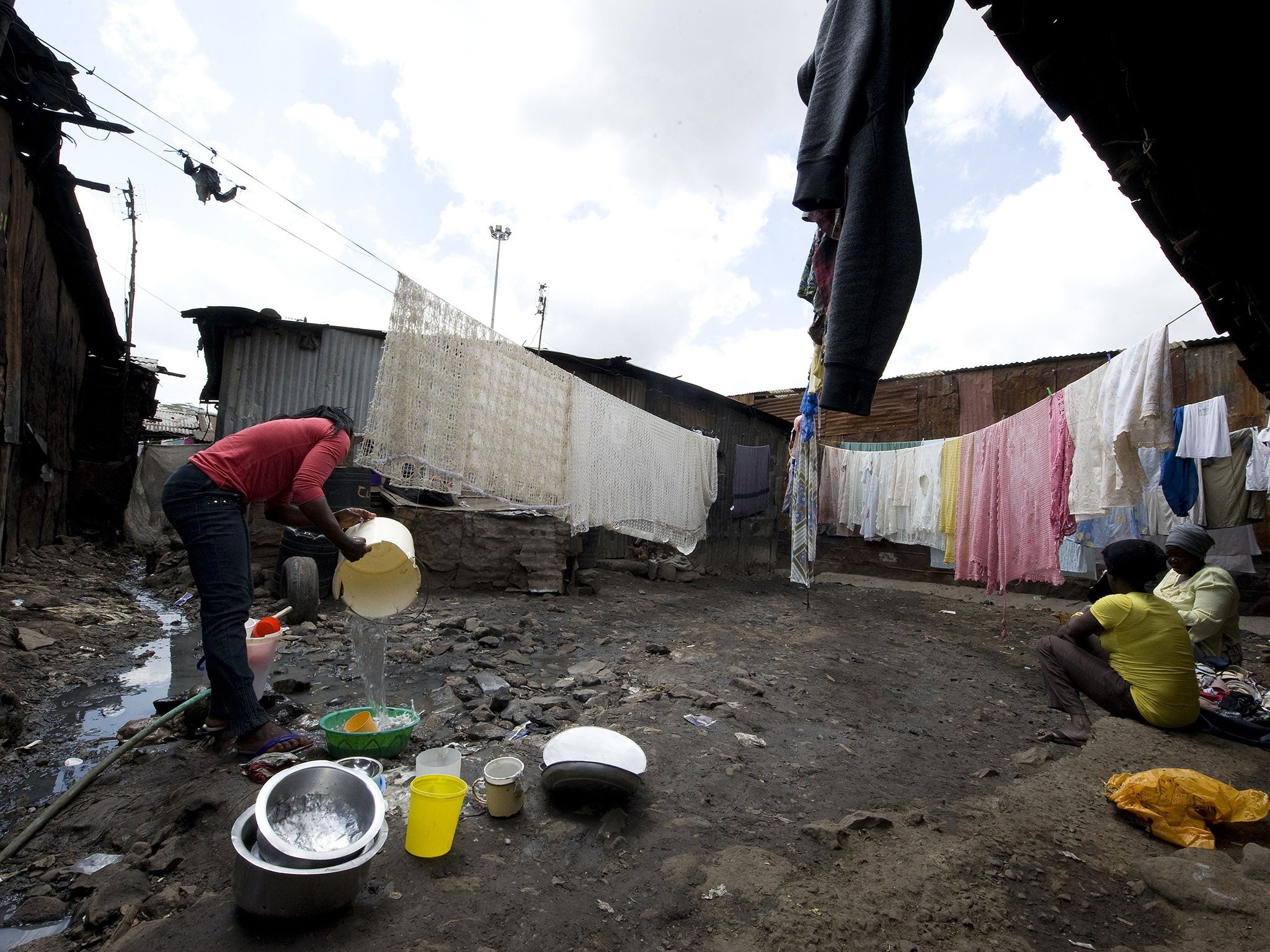 A woman washes dishes in the slum of Mathare, one of the poorest slums in Nairobi